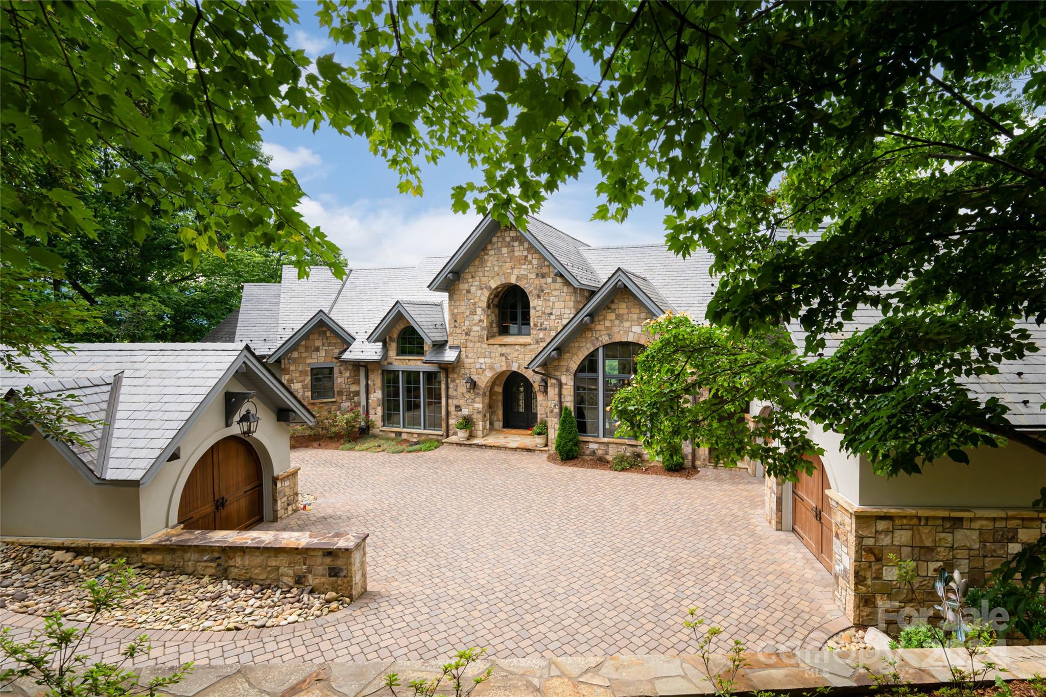 Imagine yourself waking up in this stunning masterpiece of mountain transitional architecture.  The guidance to the design team was 1) maximize the massive views across Walnut Cove and the surrounding Blue Ridge mountains, 2) the floor plan must be modern and open, 3) the home must be extremely energy efficient and low maintenance, and 4) specify a very high quality fit and finish.  The home is virtually all stone and stucco on the exterior.  The large custom windows provide incredible views of the Jack Nicklaus Signature golf course and 17,000 square foot Wellness Center below.  The geothermal heat pumps provide efficient and quiet comfort.  The landscape is expertly designed for minimal upkeep.  The home is in the The Cliffs at Walnut Cove.  One of 7 Cliffs private gated communities in the Carolinas.  You can feel remote yet enjoy the conveniences of Asheville, Hendersonville, and the airport all minutes away.