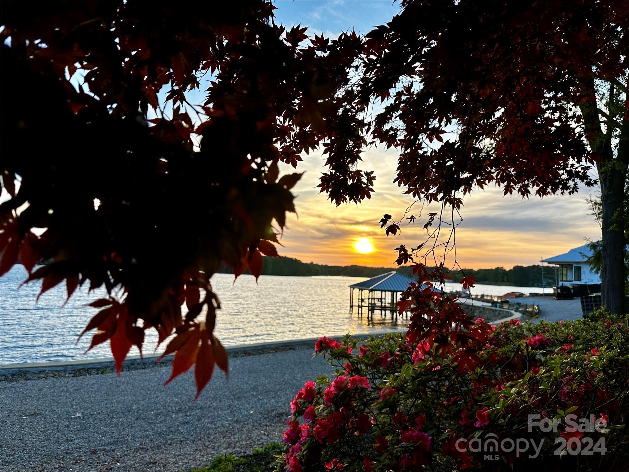 Discover your waterfront sanctuary in this custom-built 4-bed, 3.5-bath home, offering year-round water views with an expansive 484 feet of waterfront spectacle. Wake to majestic sunrises and unwind to serene sunsets over the lake, visible from your 348 feet of direct waterfront and an additional 136 feet of scenic views. This haven boasts a covered dock with boatlift, ensuring your aquatic adventures are just steps away. The heart of this retreat is a grand 2-story room, bathed in natural light from vast windows, framing the lake's beauty. Equipped with a home generator, outdoor hot tub, outdoor kitchen, and cozy fireplace, it's an entertainer's dream. A wine cellar adds a refined touch, while proximity to The Point and shopping offers convenience without sacrificing tranquility. More than a home, it's a canvas waiting for your touch. Main channel vistas, a sanctuary of relaxation.
