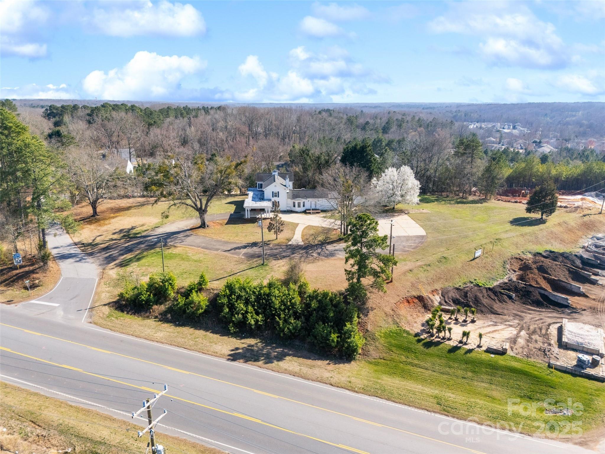 Located in a high-traffic area off Hwy 160, this prime 1.8+ acre commercial property offers exceptional potential for a variety of business ventures with zoning as Neighborhood Business. Centrally located and just minutes from popular Downtown Fort Mill, Indian Land, and Ballantyne.  This property offers the flexibility and location to help your business thrive.  The estate home with 8 bedrooms and 8.5 bathrooms, sold "AS IS, " offers incredible southern charm and elegance, with beautiful grounds, a welcoming porte-cochere, and a large front porch. Don’t miss the rare chance to own this prime commercial real estate.