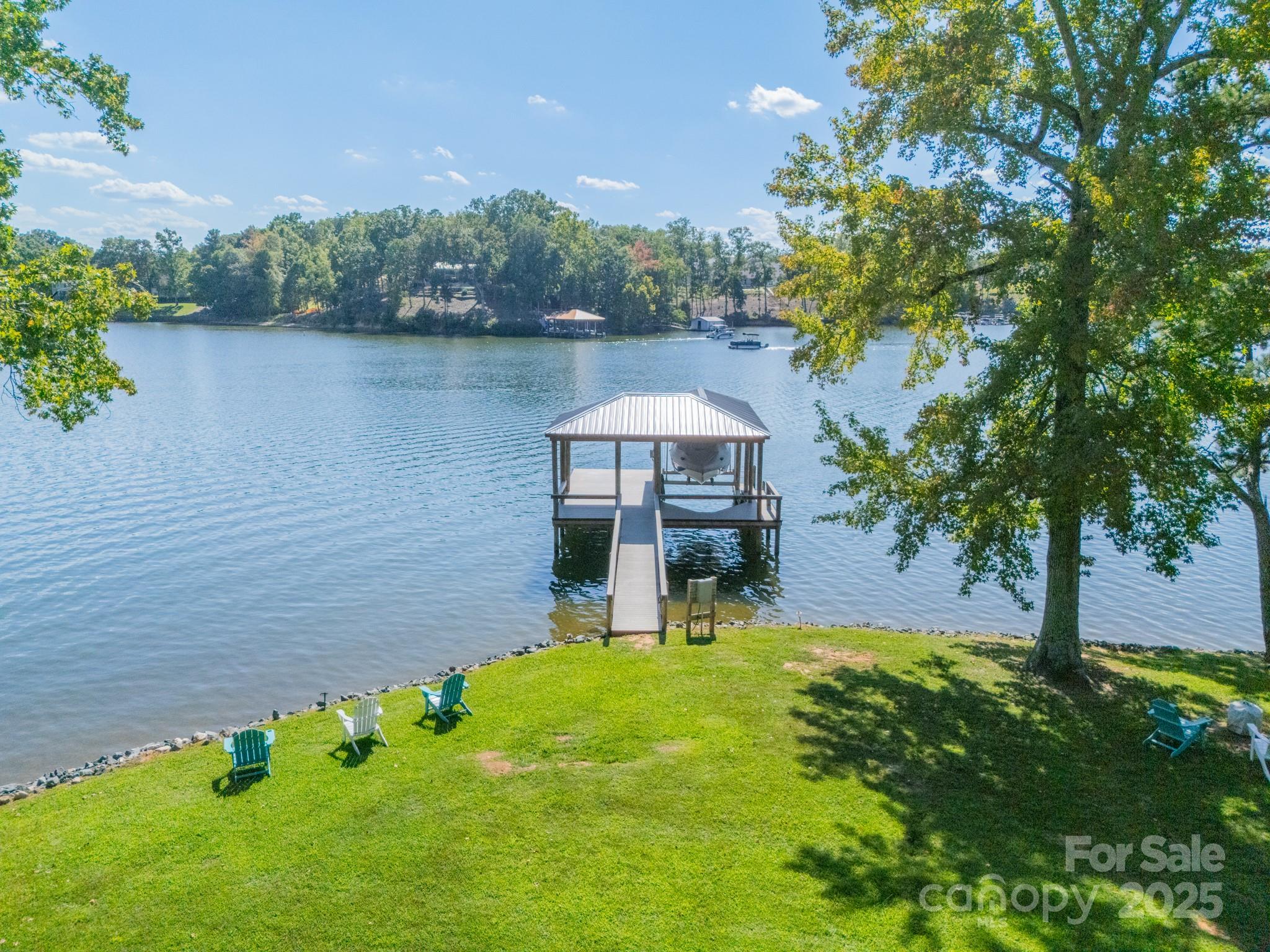 Huge lake views from this waterfront cabin with a flat lot. Newer dock built 2020 with deep water! Well maintained lake cabin is perfect as a 2nd home, weekends at the lake, and with no HOA you may offer as a short-term rental as well. Located in South Carolina not far from amenities like Publix, a new Harris Teeter under construction, Lowe's Home Improvement, WalMart, eateries and other shopping. This is a quiet location on a wide channel of Lake Wylie. Featuring two screened porches, open deck, plus a natural beach. The newer dock features Trex maintenance-free decking, 9,000 lb High Tide boat lift, wired for 100amp service, water plumbed at dock entrance and at slip - hot/cold. The roof was installed in 2001 and HVAC in 2015 per previous owner. Plumbing updated by previous owner with easy winterization valves. Much of the wiring was updated in 2020 as well. Duct work and returns were updated too. A wonderful feature is the grandfathered concrete boat ramp that was repaved - approximately 65'x12'x12". So much to love about this amazing waterfront property! Come see for yourself!!