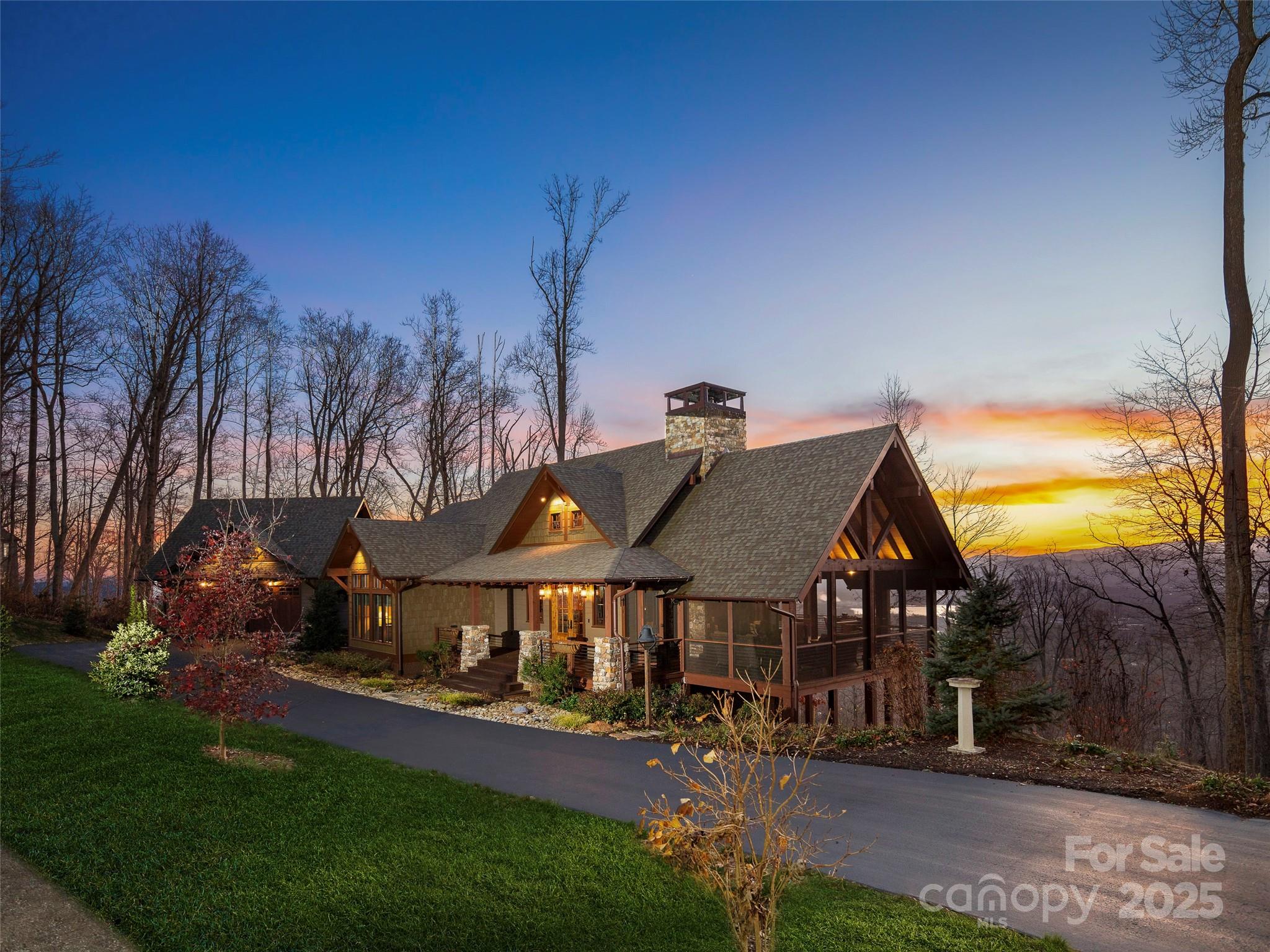 This exceptional Moss Creek-designed rustic lodge offers luxury mountain living conveniently located just 2 miles from grocery stores, restaurants and shopping. Set on over 2 acres, it boasts stunning year-round mountain views and sunsets from the covered back patio. The main level features an open yet cozy floor plan, remarkable primary suite, main level garage, and large laundry room. The lower level features a family room, two well-appointed en-suite guest rooms, office and abundant storage. This stunning home was crafted by the award-winning Living Stone Design + Build, recognized as Green Builder of the Year, with interiors by ID.ology; and was featured in Carolina Home & Garden. Highlights included a grand stone fireplace with a hand-hewn oak mantel, a wood burning fireplace in the 480 SF screened porch, Thermory decking, and a Thermador gas range. Custom ironwork and steel casement doors enhance the lodge’s character, inviting you into this exquisite Blue Ridge Mountain retreat.