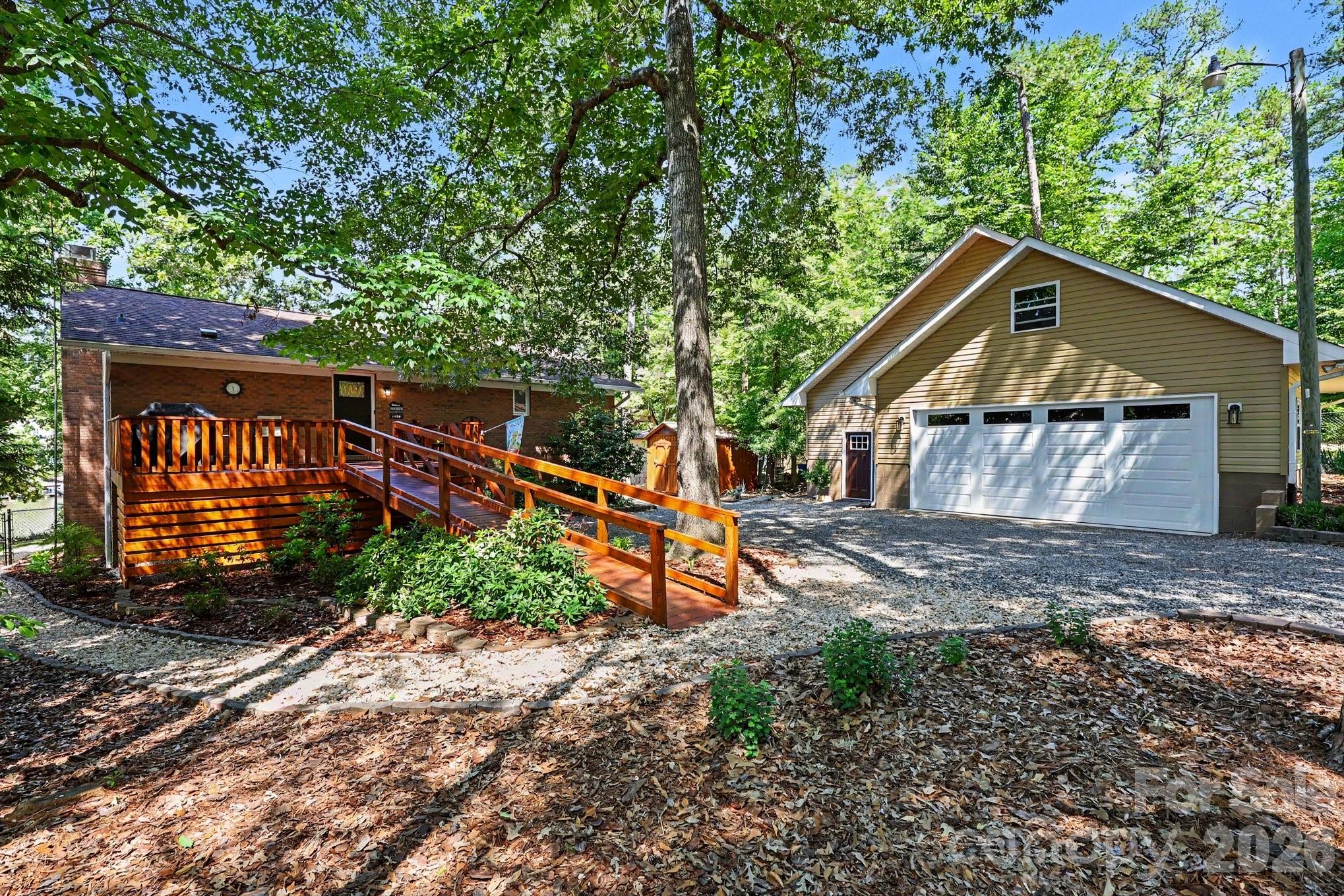 Experience the best of High Rock Lake living in this beautifully remodeled waterfront retreat, perfectly positioned in a quiet cove with easy access to the main channel. Meticulously maintained and thoughtfully updated, this exceptional property offers over 2,800 square feet of inviting living space with stunning lake views throughout.

The open-concept living, dining, and kitchen areas are designed for effortless entertaining, while the breathtaking sunroom with floor-to-ceiling windows brings the outdoors in year-round. Multiple flex spaces provide endless possibilities for a home office, media room, or additional living areas. The main level features one spacious bedroom with walk-in closet and two additional bedrooms on the lower level for guests or extended stays.

Outdoor living shines with expansive decking, a firepit, shoreline swing, rare private boat launch, and a pier/dock with floater installed in 2021 — everything you need to enjoy lake life to the fullest. Recent upgrades completed between 2019–2020 include the roof, gutters, windows, hickory flooring, lighting, kitchen enhancements, and Trane heat pumps, offering peace of mind and modern comfort.

Storage is unmatched with an oversized detached two-car garage and workshop, with walk-up attic, and an additional two-car carport. The fenced front yard with gated front entrance adds both privacy and convenience. Commercial grade kennel fence and dog condo for security and peace of mind.

This turnkey lakefront property combines luxury, functionality, and endless recreational opportunities — a rare find on High Rock Lake. Schedule your private showing today before this incredible waterfront escape is gone!
