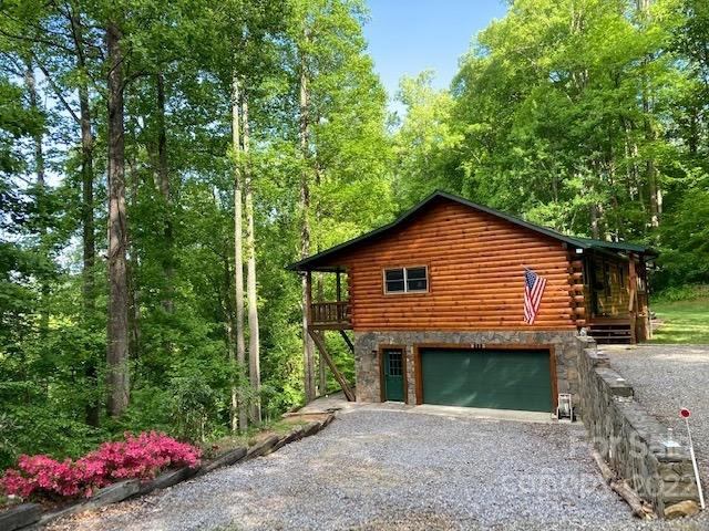 Mountain log home perched on a ridgel with beautiful views and privacy.  A very loved home in a serene setting with hardwood floors, gas log fireplace, 3 br/2ba on main level and 2 heated finished bonus rooms on lower level which could be a home office, family room or storage space. There is also a 3rd bath almost completed making it a great guest suite. Lots of wildlife off covered deck. Two and a half car garage with workshop in lower level. Main floor has a dumb waiter to bring groceries up from lower level or send wash downstairs to the W/D. Hot tub off the lower level sliding doors. (which owners have never used). This home is delightful and a perfect get-a-way. Side yard for cook-outs.  All furnishings convey with home.