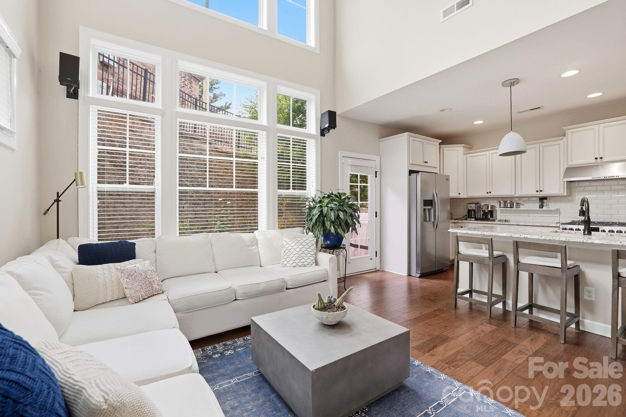 This Ballantyne gem blends modern style, smart design, and low-maintenance living in a way that just makes life easier. Built by Shea Homes in 2016, you’ll notice the quality the second you walk in.

The two-story family room is a showstopper. Sunlight pours in, giving the space an open, airy feel that’s both impressive and comfortable. It flows straight into the gourmet kitchen, where a large island, granite countertops, and stainless steel appliances set the stage for everything from quick breakfasts to hosting friends on the weekend.

The layout is what really sets this home apart. You get two primary suites: one on the main level and another upstairs. Great for guests or multi-generational living. The loft adds even more flexibility, whether you need a home office, cozy reading space, or a spot to unwind at the end of the day.

Step outside and you’ll find a surprisingly private back patio and yard. It’s perfect for morning coffee, evening wine, or relaxed get-togethers.

You get the feel of a single-family home without the weekend yard work. The HOA handles landscaping, so you can spend more time doing what you actually enjoy.

Location? It’s hard to beat. You’re just minutes from shopping, dining, hospitals, and the energy of Ballantyne AMP.