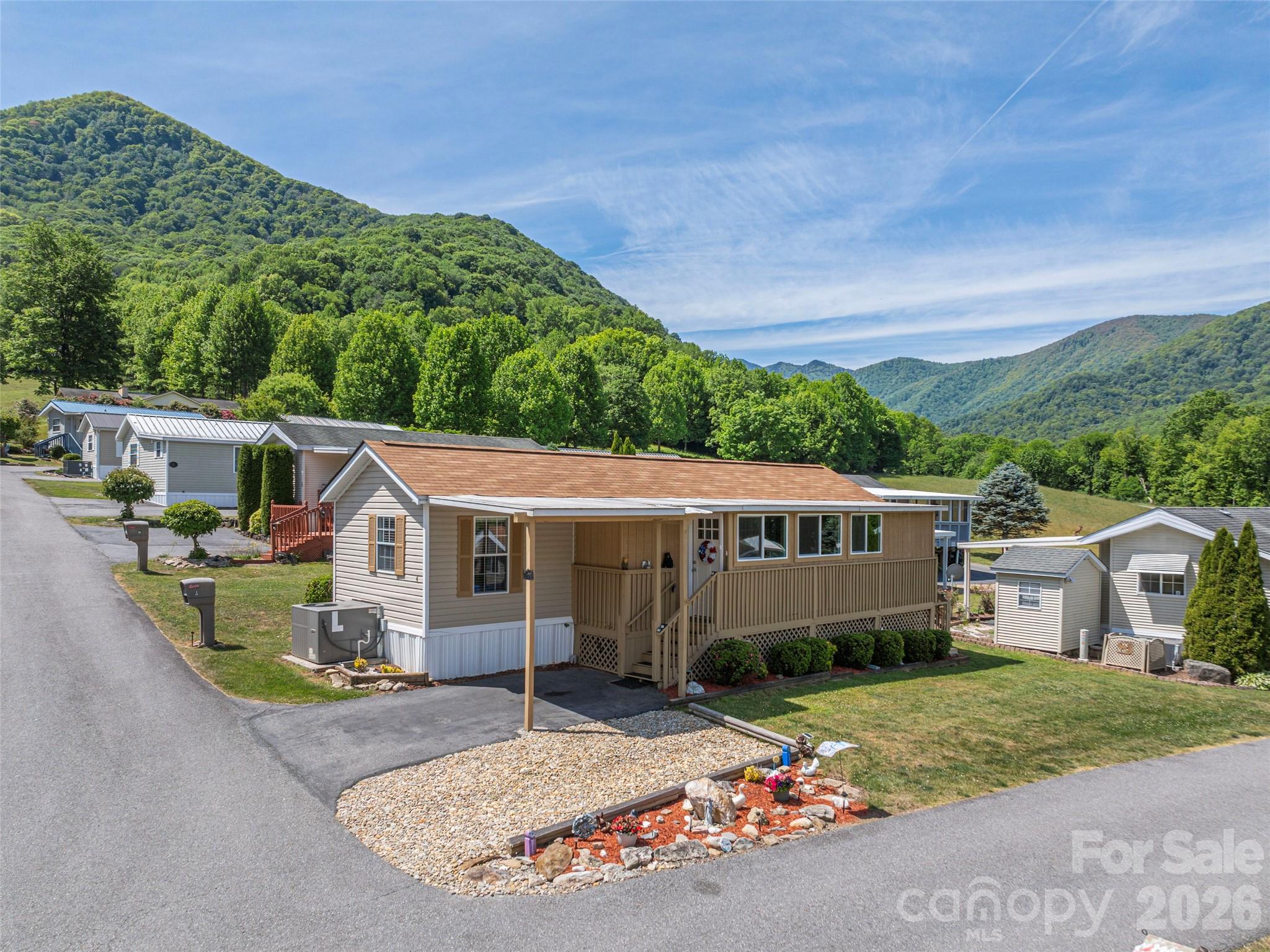 Nestled in the breathtaking Blue Ridge Mountains, this quaint 50+ community offers a unique blend of serene living and modern, affordable convenience. With stunning year-round views that change with the seasons, residents can enjoy the beauty of nature right from their doorstep. Comes Turnkey Fully Furnished. This 2 bedroom, 2 bath home has both an open concept kitchen/living area and a sun room with windows to the mountain views. Upgraded Westshore Shower in primary bathroom. New roof in 2022. Situated in the picturesque Maggie Valley Watershed, the community is surrounded by lush landscapes, where elk gracefully meander through, adding to the charm of the area. Just a short drive from restaurants, entertainment venues, and the iconic Blue Ridge Parkway, residents have easy access to both leisure and adventure. Embrace an active lifestyle with nearby hiking trails, parks, and outdoor activities that promote wellness and connection to nature. This community perfectly balances tranquility with accessibility, making it a haven for those seeking to enjoy life among the mountains. No rentals allowed.