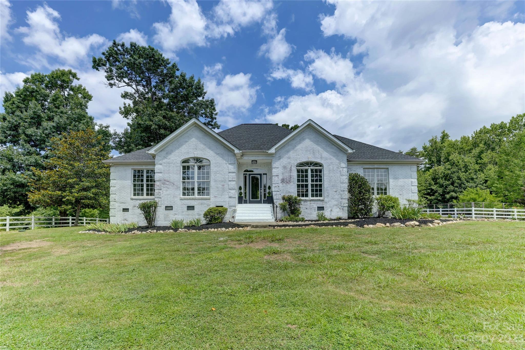 Introducing a truly remarkable property in sought-after Fort Mill, South Carolina! Nestled on over 12 acres, this equestrian haven offers a unique blend of spacious land and modern comforts. The meticulously updated interior boasts a sleek, contemporary kitchen and bathrooms that will impress even the most discerning buyer. Privacy is paramount here, with no neighbors in sight, rendering blinds unnecessary. The fenced pasture land and horse stalls in the barn provide an ideal setup for equestrian enthusiasts. Additionally, the barn features a separate living quarters, while a designated area awaits chickens, goats, and a thriving garden with raised painting beds and a greenhouse. Uniting the best of both worlds, this exceptional property allows you to enjoy the acclaimed school district Fort Mill is known for, while relishing int he serenity and acreage that are rarely found. Don't miss the opportunity to embrace this unparalleled gem tailored to equestrian dreams.