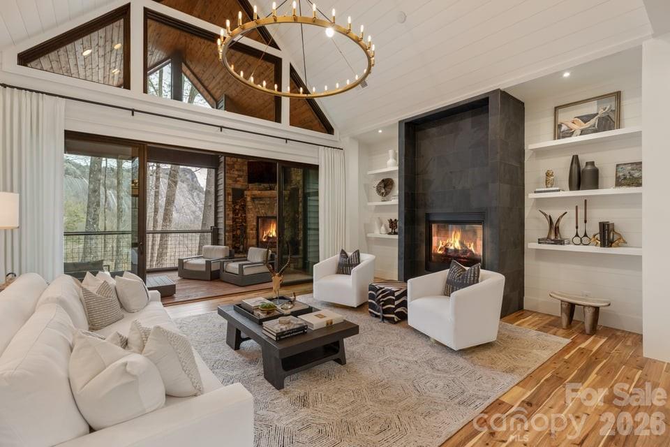 Built in 2021 and positioned on approximately 1.96 acres, this contemporary mountain residence offers refined craftsmanship, modern comforts, and striking Whiteside Mountain views from every room on the main level and many rooms on the lower level. Located within the gated Cullasaja Club community in Highlands, NC, the home captures the relaxed elegance and natural beauty of the Highlands-Cashiers Plateau.

The main level centers around a spacious great room with soaring ceilings and a gas fireplace shared with the primary owner’s suite. Expansive sliding glass doors frame the mountain landscape and open to a screened porch with a wood-burning fireplace, creating a seamless indoor-outdoor living experience. The porch connects to an open deck accessed from the primary suite.

The primary bedroom is located on the main level and features mountain views along with a generous ensuite bath that includes a soaking tub, glass walk-in shower, and walk-in closets.

The kitchen blends clean design with high-end functionality and features built-in appliances including a gas stove and double ovens. A formal dining area and casual dining space provide flexibility for everyday living and entertaining.

The lower level offers additional living space designed for comfort and recreation. Two guest bedrooms share a Jack-and-Jill bath, while the recreation room includes a fireplace, pool table area, and wet bar. Sliding doors lead to a covered deck with a hot tub.

Large windows throughout the home bring natural light indoors while showcasing the impressive mountain views.

Approved membership provides access to Cullasaja Club’s world-class amenities, including an Arnold Palmer–designed championship golf course, clubhouse dining, wellness facilities, tennis, swimming, and a vibrant social calendar. Additional features include lake access to Ravenel Lake and an extensive trail network throughout the community, with connections to the adjoining National Forest.