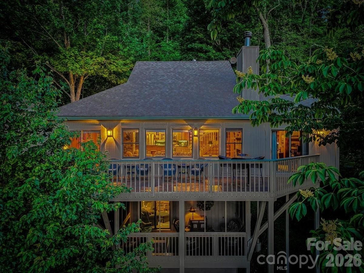 Enjoy privacy and long-range, mountain views from this fully furnished, beautifully expanded Sportsman’s Cottage in the private, gated community of MOUNTAIN AIR. Priced to sell quickly, this home is perfectly situated on a curve for added space and seclusion. This 4-bedroom, 4-bath + office single-family home offers over 2,400 square feet of heated and air conditioned living space—a true mountain retreat with room for family and friends. Inside, hardwood floors flow through an open main-level living area that combines comfort and style. The kitchen features granite countertops, stainless appliances, and opens to the great room showcasing mountain views through large front windows. A floor-to-ceiling stone, wood-burning fireplace in the living room also has a propane line for transition to gas logs if you prefer. The great room has been expanded, providing the living and dining areas more flexibility. The expanded primary suite includes a home office area with a view, a spacious ensuite bath with a spa shower, a soaking tub, a private water closet, a built-in vanity, heated floors and spacious his and hers walk-in closets. With a no-stairs entry, you’ll find convenient one-level living—primary suite, guest bedroom and bath, laundry, and great room all on the main floor. Additional guest suites on the upper and lower levels feature ensuite baths. Upstairs includes an outdoor deck; downstairs features an enclosed porch for those rainy days, fresh mountain air and cozy relaxation. The property also includes a one-car detached garage plus a golf-cart garage. Residents enjoy hiking trails, seven beautiful parks, and the highest private runway east of the Mississippi. A short cart ride or walk brings you to Mountain Air Country Club amenities, including golf, tennis, pickleball, fitness center, spa, dining, and more, available with separate membership.
