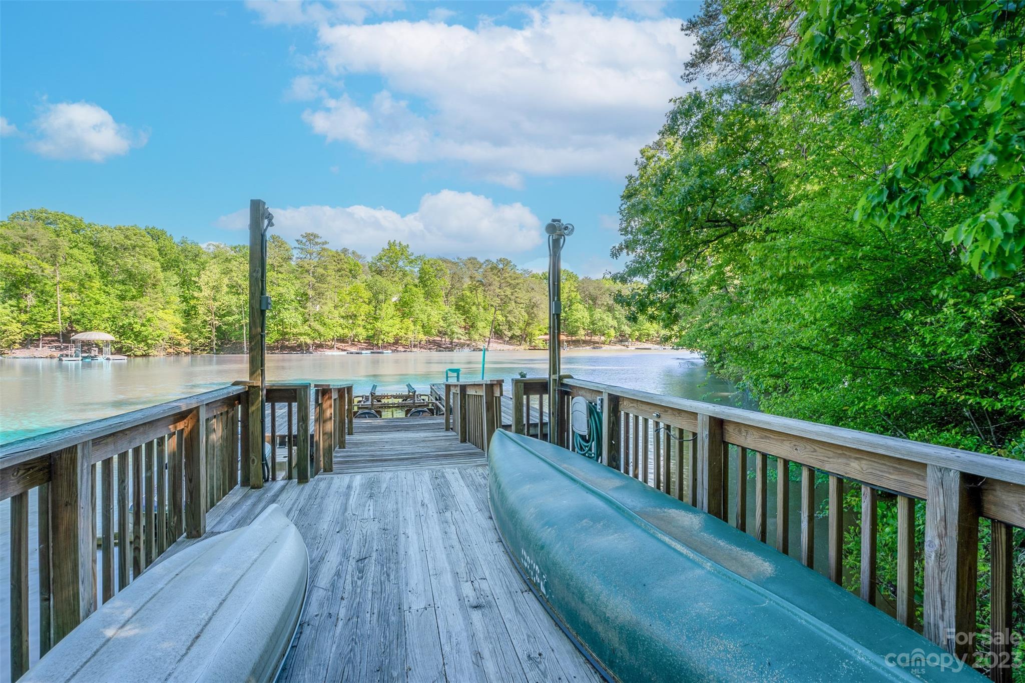 Welcome to lake life! Nestled on a serene 1.80 acre lot in Heron Bay, this private lake front home is ready for new owners! From the moment you enter, you will see how the natural surroundings outside are visible from the full wall of windows facing the lake. The open floor plan flows to the outside entertaining space which includes a large deck, a screened porch off the primary suite, and a covered patio on the walkout basement level, all overlooking beautiful Badin Lake! The cook in the family will enjoy the view while in the kitchen or grilling outside. The spacious primary bedroom has lovely built in cabinetry and a private entrance to the screened porch. Upstairs features two bedrooms and a full bath. The 1700+ sq foot basement has endless possibilities with another wall of windows and a full finished bath. Stroll down to the dock to relax and watch nature or hop on your boat and head to Cheers or Scallywags for lakefront dining and entertainment. Lake life is calling!