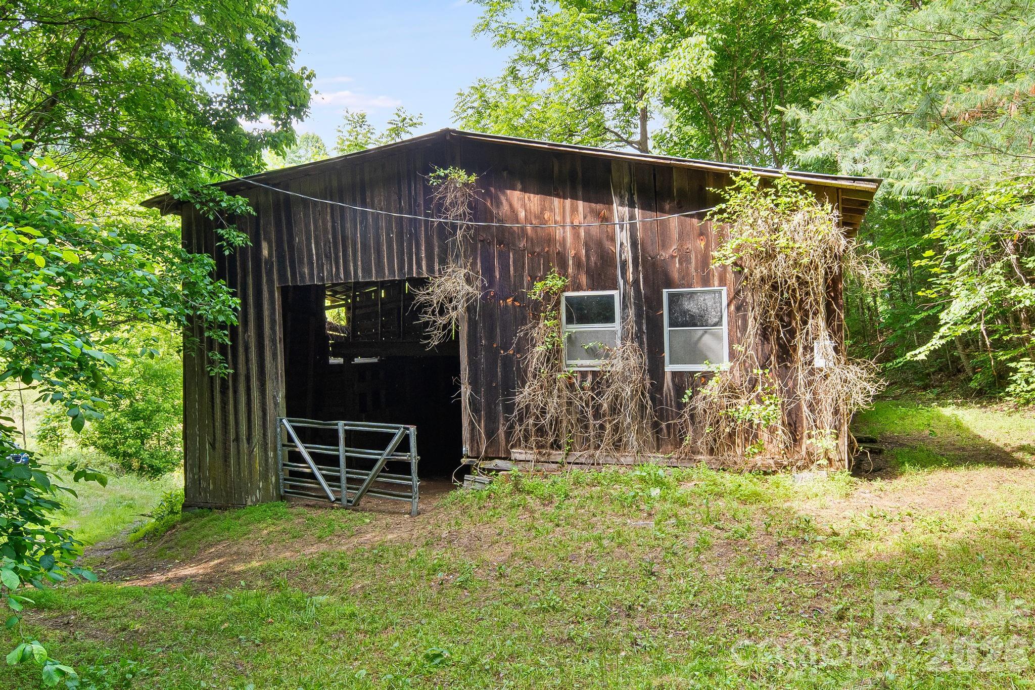 Nearly 15 acres of pristine Madison County mountain land offering privacy, natural beauty, and endless possibilities. Conveniently located just 10 minutes from the charming restaurants, shops, galleries, and restaurants of downtown Marshall and only minutes from the French Broad River, this exceptional property combines seclusion with easy access to outdoor recreation and local amenities.

A network of well-groomed logging roads winds throughout the property, making it easy to explore on foot, ATV, or utility vehicle. Enjoy these established roads as private hiking trails as they lead to three potential homesites, including a spectacular ridgeline build site with stunning long-range mountain views.

The property also features a spacious tobacco barn with electricity already connected and a well-built auxiliary structure that could serve as a workshop, studio, storage building, or potential off-grid retreat. Tucked away in a peaceful setting between Bear Creek and Little Pine Road, the land offers a wonderful blend of mature forest, privacy, and usability.

Whether you're seeking a private mountain estate, family compound, recreational getaway, or future homestead, this unique Madison County property is ready to inspire your vision. Explore the trails, enjoy the mountain views, and experience the best of Western North Carolina living.