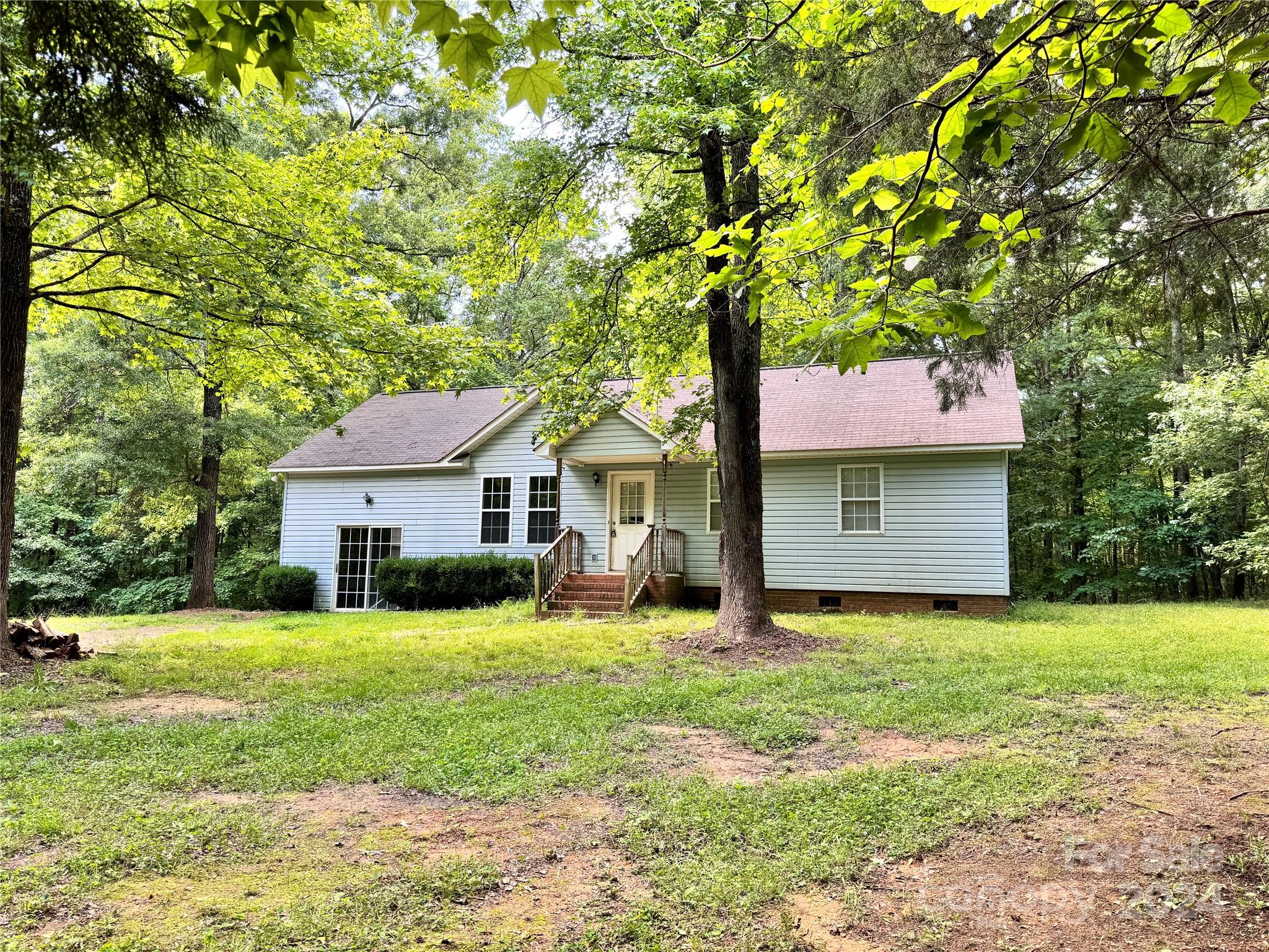 Welcome to your private oasis! This charming ranch home sits on a sprawling 2.46-acre wooded parcel, complete with a tranquil stream meandering through the property. The open floor plan and vaulted ceilings create an inviting and spacious atmosphere. The garage has been thoughtfully converted into a heated and cooled rec room, offering additional space for entertainment or relaxation. Access to the property is convenient with an easement in place. Experience the serenity and seclusion of this unique home. Don't miss the opportunity to make this your dream retreat!