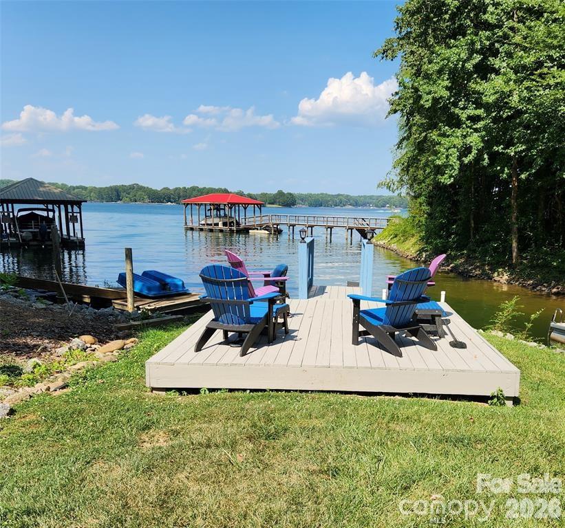 PRICE REDUCED BELOW MARKET VALUE!!!  Waterfront home with amazing sunrises & sunsets year round. 3 Bedroom 3 Full Bath Ranch home with finished walk out basement. Large Front Porch and full length upper deck as well as a covered patio.  Grab your morning coffee and take in the Lake views.  End the day at the covered patio and soak in the hot tub or unwind at the deck by the Lake. Stairs going down into the Lake so you can enjoy kayaking, cool off or take a swim. Cozy up on a cool day in front of a wood burning fireplace upstairs or the woodburning stove downstairs.  We have rented a great boat slip just down the road or you can park boat at property and use community ramp across the street.  Updates: Roof in 2017, windows, bathrooms, and kitchen. 2020: HVAC with new duct work upstairs and 2 mini-splits downstairs, all carpet was removed and replaced with beautiful wood floors upstairs & luxury vinyl plank down. 2026: New well pump and tank.  Volunteer HOA includes use of Day Dock, Boat Ramp & fire pit / picnic area. Whole House Generator, (tank is leased), Whole House Water filter system, & Hot Tub are included. Short-term rentals are allowed.  Owner is Agent.