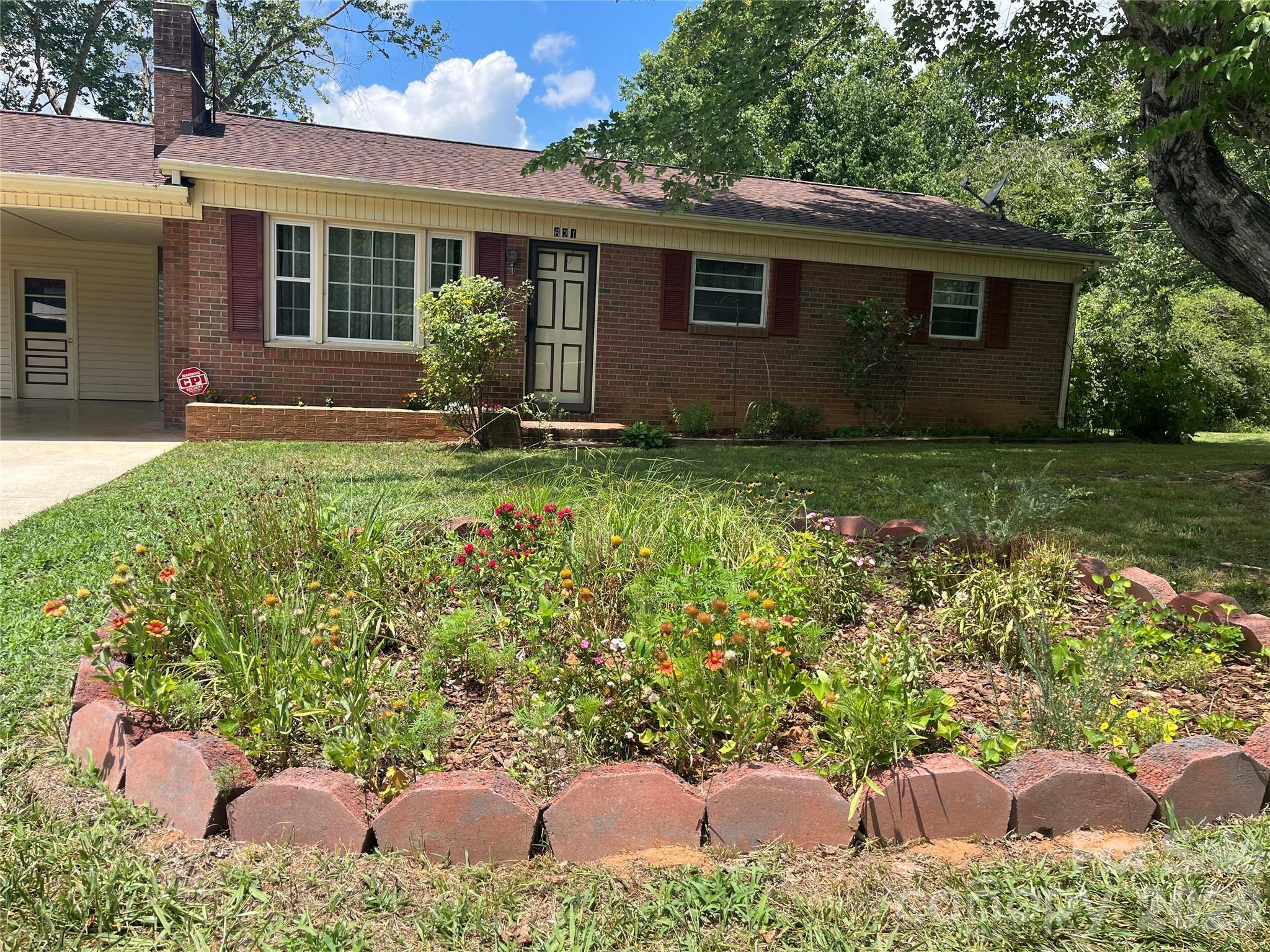 Charming home in the desirable Hudson/South Caldwell school district, with convenient access to Lenoir and Hickory. This corner lot home is perfect for first-time buyers or someone looking to downsize.  Includes a large yard with a brand new deck off the first floor. Two bedroom, 1 bath home with central A/C features large family spaces, including a 22 x 11 living room -- with a potential home office space -- and a 16 x 14 eat-in kitchen/dinette area.  Original hardwood floors throughout with newer laminate flooring installed in the kitchen/dinette area. Internal spiral staircase leads to unfinished walk-out basement. An attached carport with storage room plus outdoor 12 x 10 storage shed provides plenty of storage space. Enjoy a relaxing, country lifestyle with easy access to town amenities.