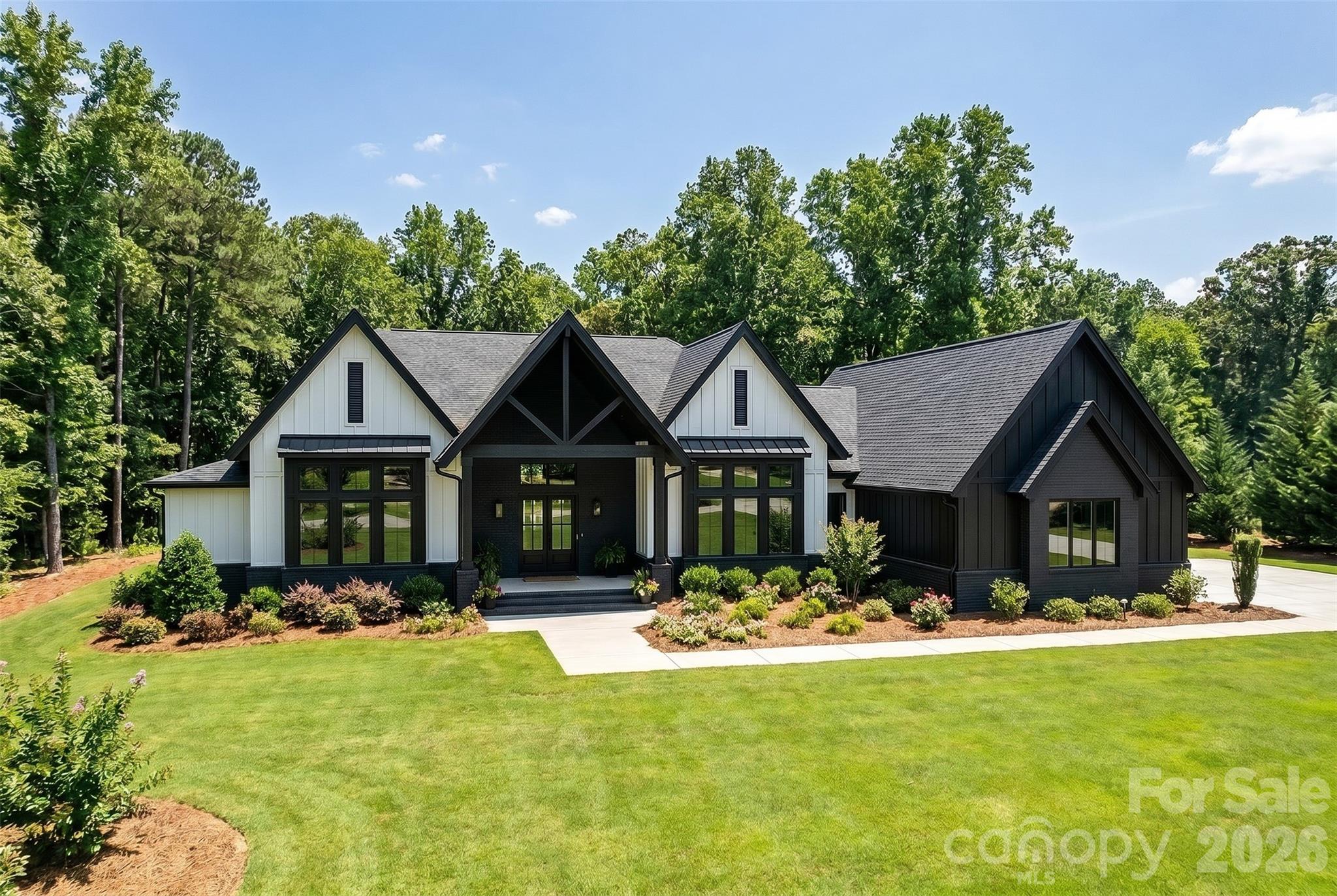 Welcome to a home where timeless southern architecture meets refined modern living — a masterpiece set on a serene one-acre homesite in the heart of Fort Mill, South Carolina. Nestled in a tranquil setting just moments from Fort Mill’s charming downtown, scenic parks, and with easy access to all that Charlotte has to offer, this custom-built estate perfectly balances privacy, sophistication, and convenience. Step inside to discover light-filled living spaces that flow effortlessly through a thoughtfully designed open floor plan, ideal for both intimate gatherings and grand entertaining. The luxurious ranch design with a walk out lower level featuring four spacious bedrooms, each with its own private en suite bath, offering comfort and elegance for owners and guests alike. Private den / office on the main floor.  The heart of the home is its gourmet kitchen and expansive great room, where natural light pours through large windows, highlighting the home’s impeccable craftsmanship and inviting warmth. The primary suite is a true retreat, complete with a spa-inspired bath designed for relaxation, featuring fine finishes and a calming ambiance The lower level features a spacious living area with a full kitchen, 4th bedroom w/ en suite bathroom, 2nd laundry room. Every detail has been curated to showcase the beauty of Southern traditional design from the custom finishes to the graceful transitions between indoor and outdoor living. Outside, an expansive covered rear porch invites you to unwind or entertain while overlooking the lush one-acre setting — the perfect backdrop for a future pool. A three-car garage completes the home’s thoughtful design and functionality. Experience a home where luxury and natural beauty live in harmony — where every space tells a story of craftsmanship, comfort, and timeless style. This is more than a home. It's a statement in southern living.
