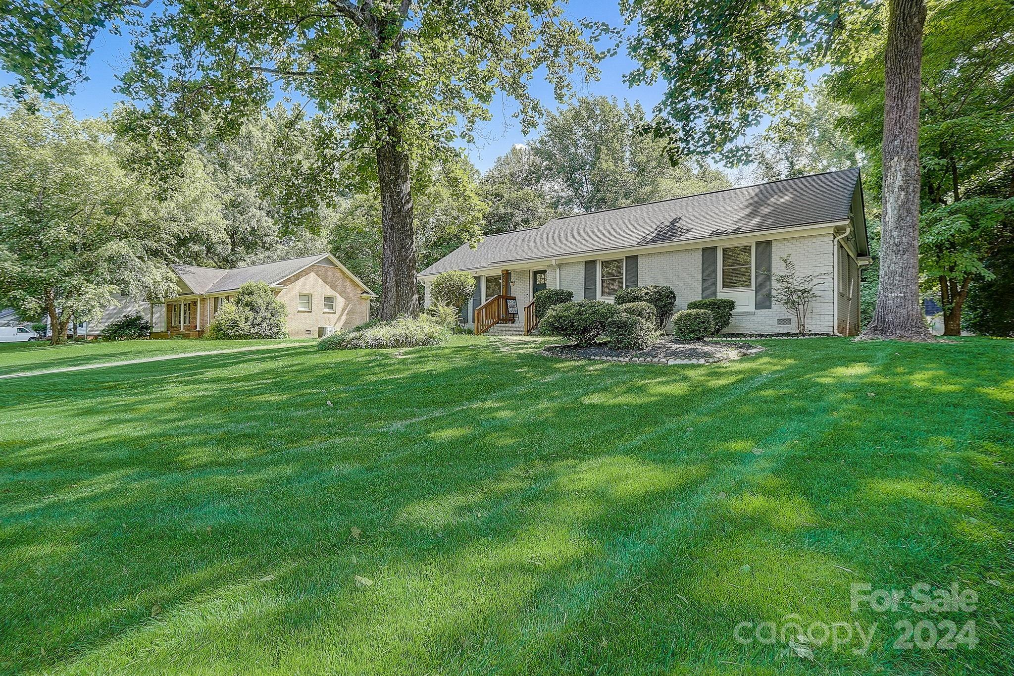 Welcome to this updated ranch home in the desirable Hampshire Hills! W/ 4 bedrooms and 2 bathrooms, this residence boasts a well-maintained yard and freshly painted brick exterior, enhancing its curb appeal. Enjoy beautiful hardwood floors and large windows that fill the open-concept floor plan with natural light. The modern kitchen is a chef's delight, equipped with stainless steel appliances, quartz countertops, a stylish backsplash, shaker cabinets, a large island, and updated light fixtures. The spacious primary bedroom offers a serene retreat with an ensuite bathroom featuring dual vanities and a tiled walk-in shower! Three additional bedrooms provide ample space for guests, family, or flexible use. Outside, the large back deck overlooks meticulously maintained fescue grass and a tree-lined yard, ensuring privacy. Located just a short drive from Uptown Charlotte, this home offers the perfect blend of suburban tranquility and urban convenience.