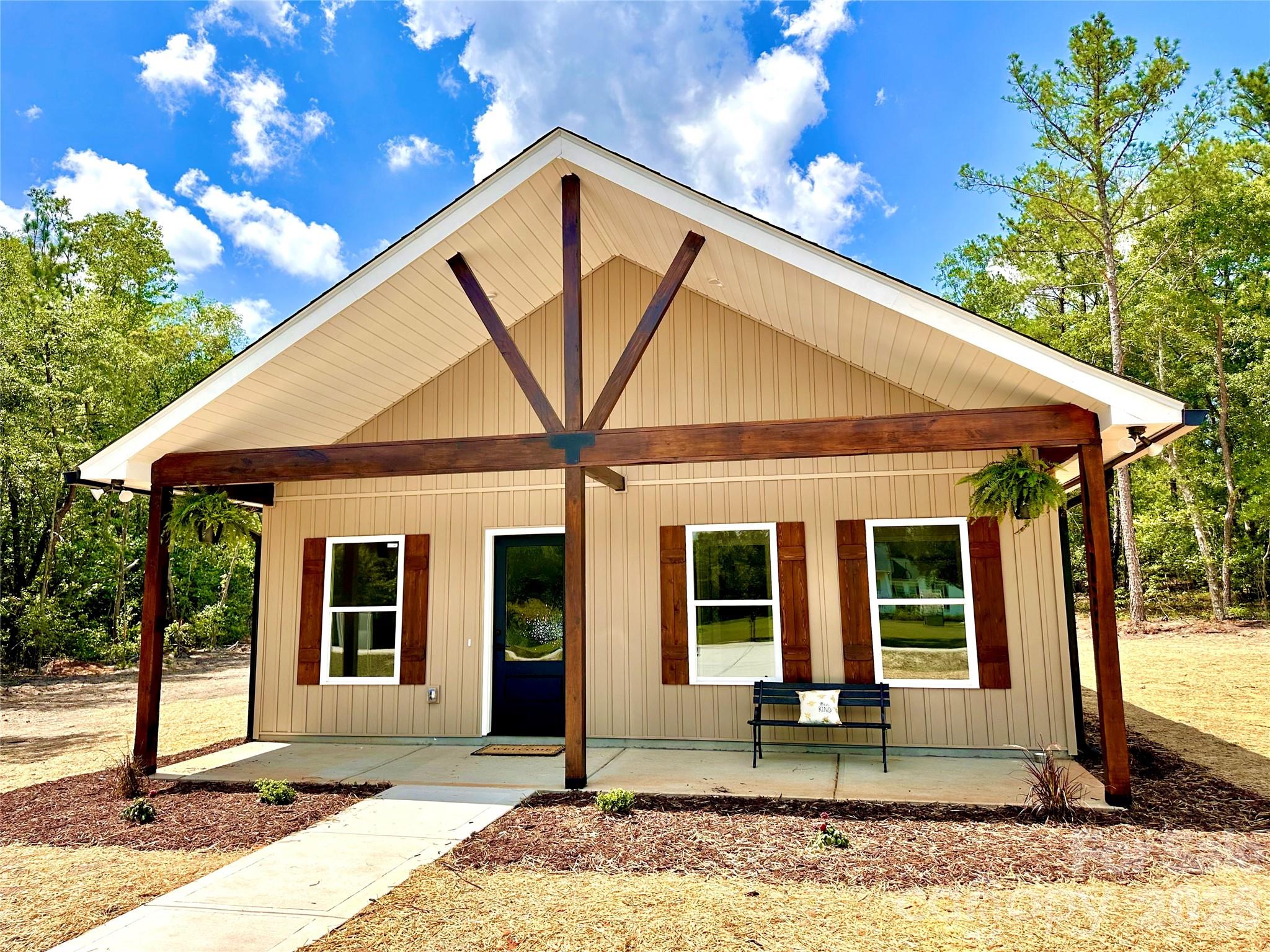 Construction to be completed by end of July. Experience modern luxury in this stunning new farmhouse-style ranch. Thoughtfully designed with high-end finishes, this home showcases craftsman soft-close cabinetry, elegant quartz countertops and subway tile backsplash, LED recessed lighting, and ceiling fans with remotes. LVP flooring flows seamlessly throughout, offering both style and durability. Set on a spacious, private wooded lot, this residence provides a serene retreat away from busy traffic—paired with the benefit of low taxes.