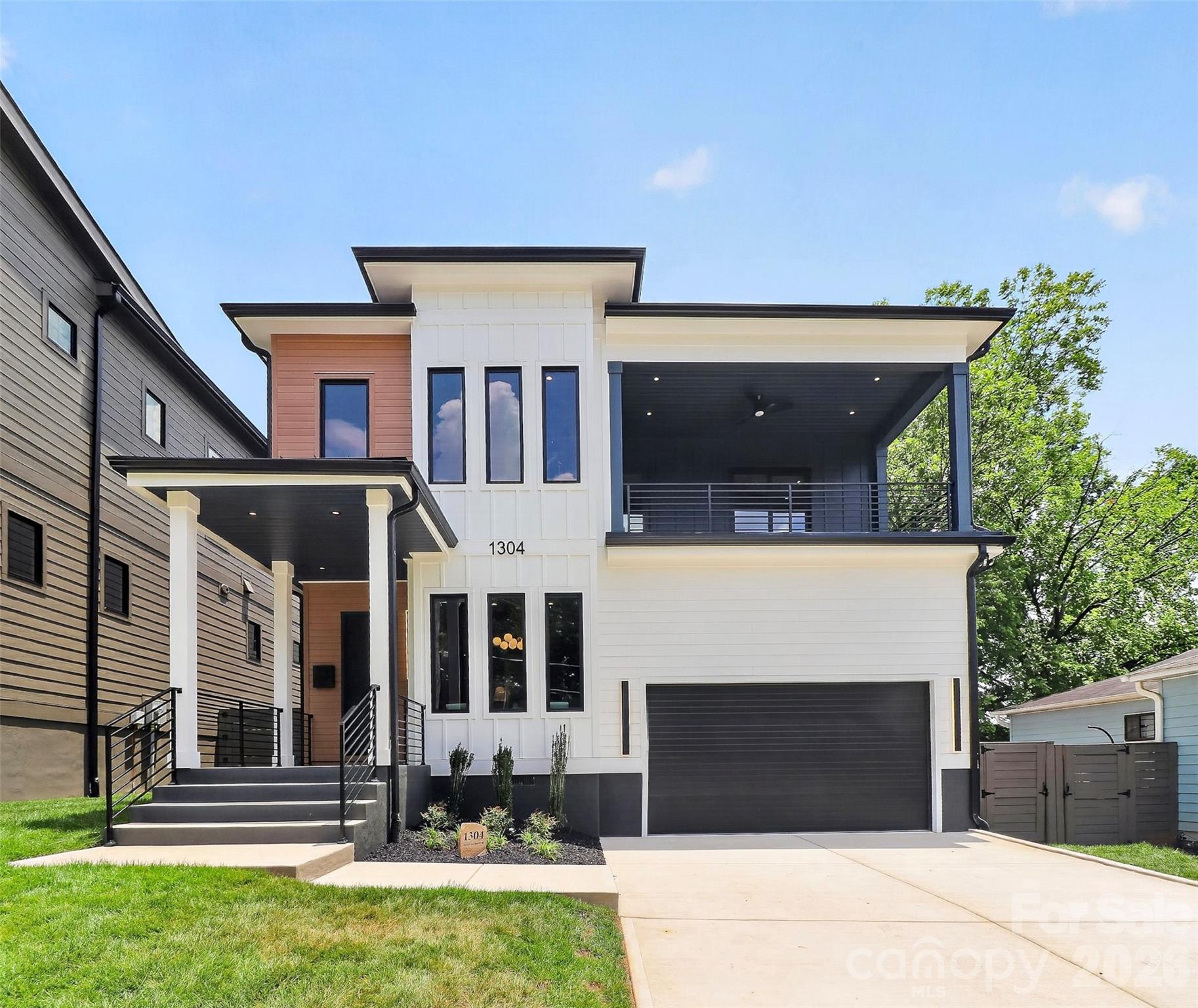 Modern 2-story home in desirable Optimist Park featuring 4 bedrooms, 3.5 baths, and designer finishes throughout. Open-concept floor plan with all hardwood flooring and a dedicated office with modern glass barn door.  The chef’s kitchen showcases a waterfall-edge island, 48" dual-fuel range with griddle, custom hood, full appliance suite, large pantry, and entertaining bar with wine cooler and floating shelves. Family room features a stunning tiled fireplace, while the dining area is accented with designer sconces.  Upstairs, the spacious primary suite opens to a covered porch with incredible city views and includes a luxurious bath with a large tiled shower. Three additional bedrooms include an ensuite and a Jack-and-Jill bath. Additional features include a second coffee/beverage bar, upstairs laundry with cabinetry, tankless water heater, and designer lighting throughout.  Enjoy a covered porch, fenced and sodded backyard, plus a painted 2-car garage with epoxy floors, high ceilings, and side-mount openers. Exceptional modern living in one of Charlotte’s most sought-after neighborhoods.