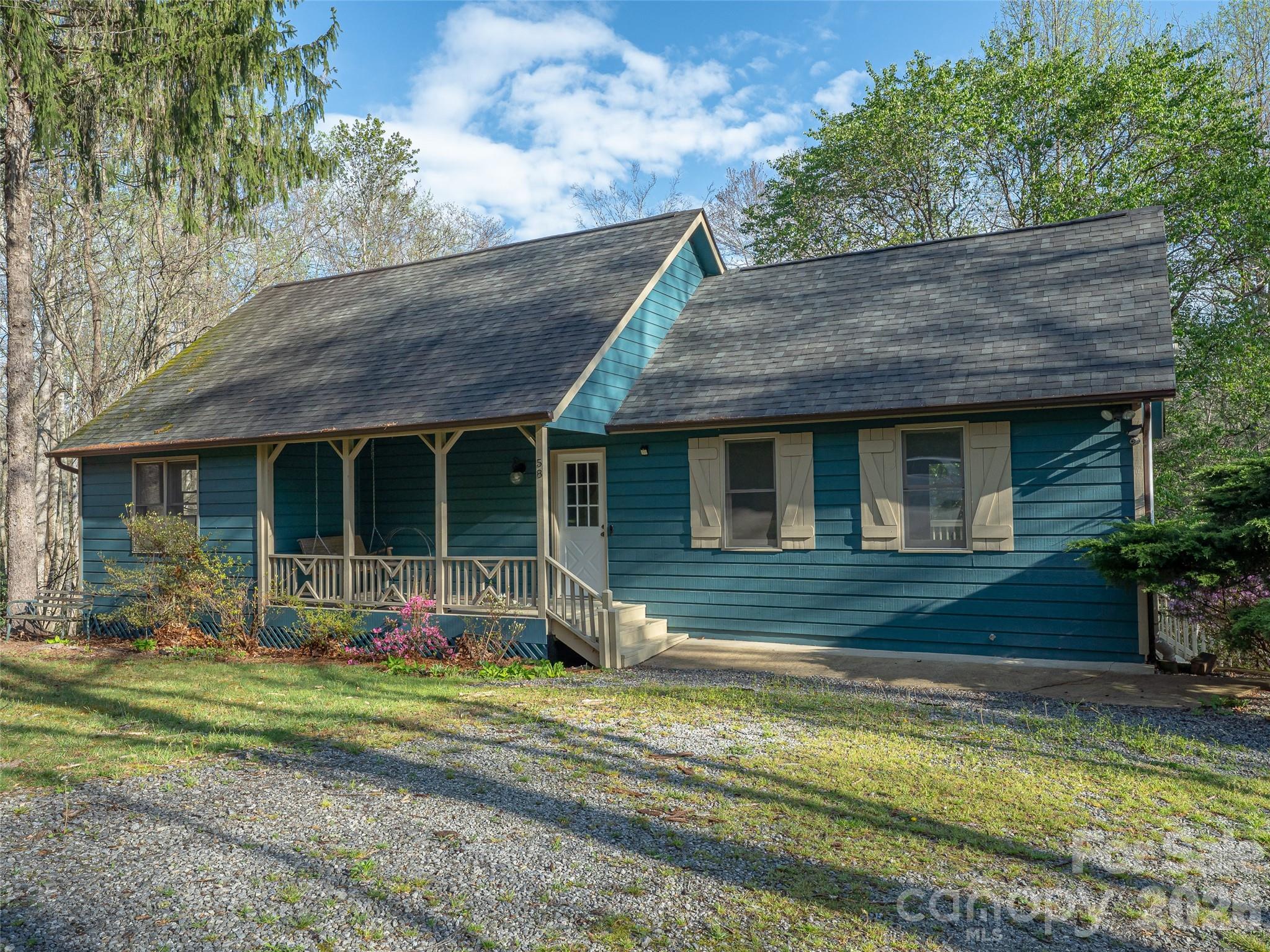 Discover the perfect blend of privacy, charm, and mountain living in this beautiful 2BR/1.5BA cottage on serene private property. The freshly painted interior enhances the warm and inviting great room, featuring cathedral ceilings, a cozy wood-burning stove, and rich hickory floors flowing throughout the open floorplan. The spacious kitchen and dining area make entertaining easy, while the main-level primary suite offers comfort with its own ensuite bath, plus a flexible office/bonus room and convenient main-level laundry. Upstairs provides a large second bedroom and a charming reading nook. Outside, enjoy the freshly painted covered porch with swing, an expansive freshly painted deck, a circular driveway for convenience, and a standing-height crawl space perfect for storage. This tranquil cottage offers exceptional comfort, character, and privacy, ideal for full-time living or a peaceful mountain retreat.