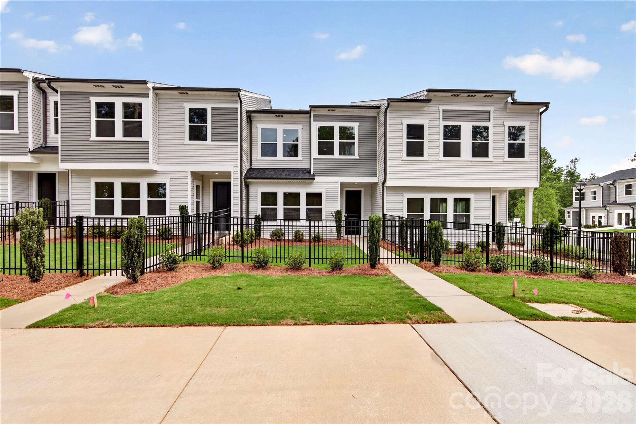 Welcome to 6315 Haller St, a 3-bedroom, 2.5-bath townhome with a covered front entry, fenced front yard, and 2-bay rear-load garage designed for easy, everyday living. The open-concept first floor is anchored by a chef-inspired kitchen featuring white cabinetry, white quartz countertops, white subway tile, a large single-bowl stainless steel sink with a Delta Essa Touch faucet, and a GE 30" freestanding electric range — plus tucked-away storage under the stairs. Upstairs, a loft sets the tone before leading to all three bedrooms, including a primary suite with a walk-in shower with tiled walls, white cabinetry with drawers, white quartz countertops, and a walk-in closet. A dual-vanity secondary bath, upper-level laundry room, and LivingSmart features, WiFi switches, HomeSmart thermostat, prewired ceiling fans, and a Ring doorbell, round out the home. All of this at Amplitude, a thoughtfully located townhome community offering bright, airy interiors, low-maintenance living, and easy access to Uptown in one of Charlotte's most exciting and fast-growing corridors.