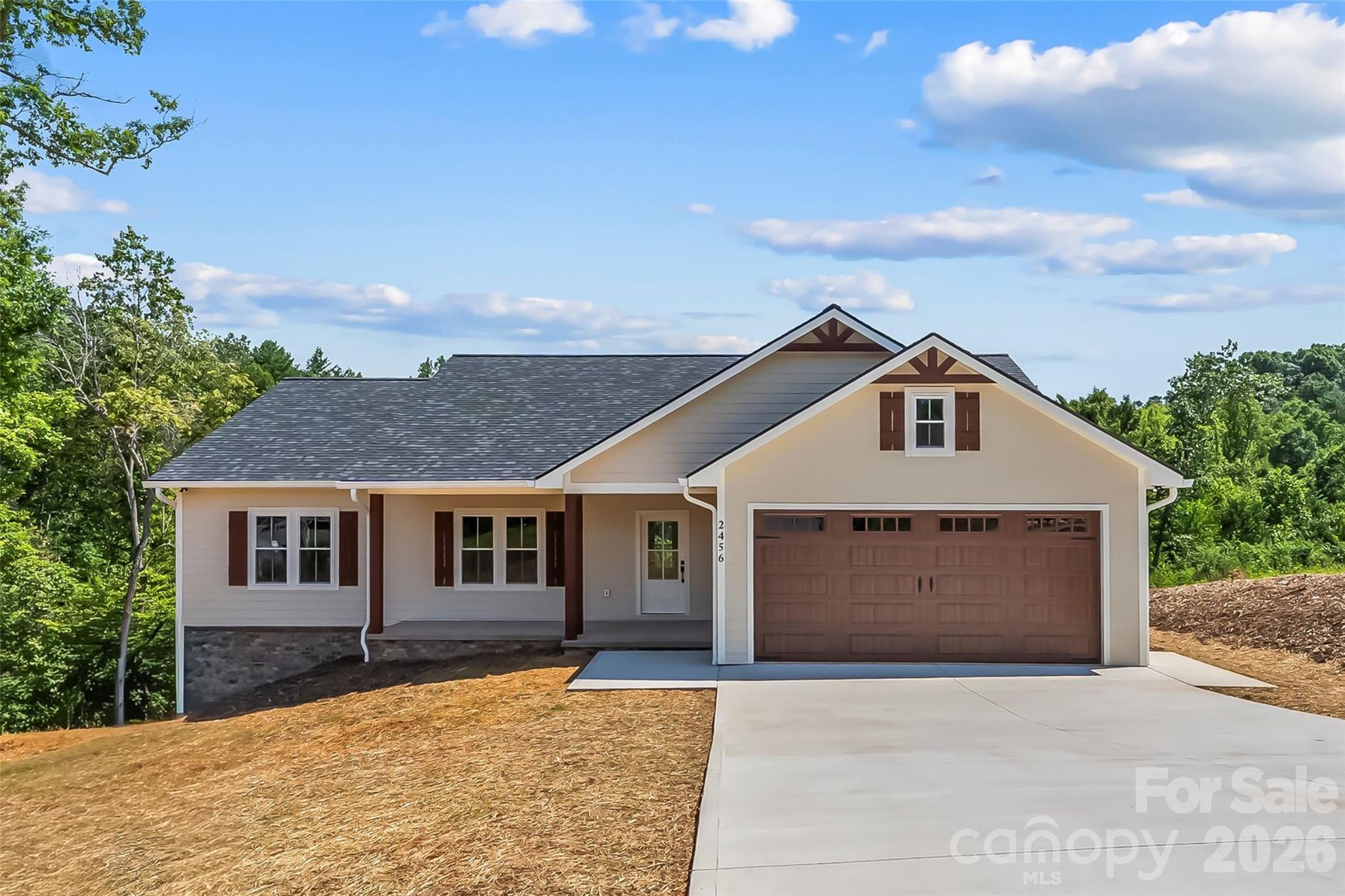 Stunning New Construction on 1.26 Acres! Welcome home to this beautifully crafted 3-bedroom, 2-bath ranch offering quality craftsmanship, modern finishes, and move-in-ready convenience. Thoughtfully designed with an open-concept floor plan, this home is perfect for both everyday living and entertaining. The spacious kitchen serves as the heart of the home, showcasing custom soft-close dovetail cabinetry, gorgeous quartz countertops, a large center island, breakfast bar, pantry, and stainless steel appliances. The open living and dining areas flow seamlessly together and are accented by beautiful ¾-inch white oak hardwood floors, adding warmth and timeless elegance throughout the main living spaces. Retreat to the private primary suite featuring a generous walk-in closet and a en-suite bath. The conveniently located laundry room, situated just outside the primary suite, adds ease to your daily routine. Two additional bedrooms provide plenty of space for family, guests, or a home office. Step outside to enjoy the covered front porch with its charming tongue-and-groove ceiling, or unwind on the back deck overlooking the expansive 1.26-acre lot. Stairs lead down to the backyard, where a peaceful creek winds through the rear of the property. Custom shutters enhance the home's curb appeal, while the attached two-car garage provides everyday convenience. If you're looking for quality construction, stylish finishes, situated on a spacious lot, this beautiful new home is one you won't want to miss!