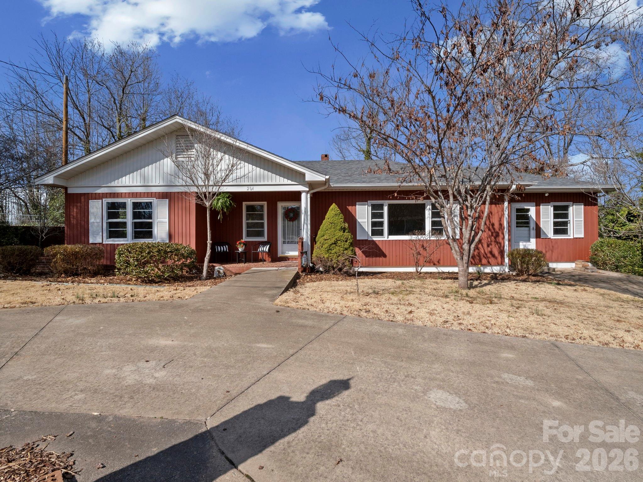 Rare find in established Fernwood neighborhood just minutes from restaurants and shopping in historic downtown Rutherfordton. Perfect location to walk the quiet and peaceful neighborhood or ride bikes to downtown.  Well built one story home with full basement and lots of new updates and entire house painted, . Move in ready ! The concrete circular drive gives easy access to front one level entrance . This home features low maintenance premier exterior Metal siding , a brand new architectural shingle 50 yr warranty roof, and luxury vinyl plank flooring. This home boasts an oversized Living Room and Dining room with a cozy fireplace surrounded by custom built in shelves. The three bedrooms are all on the main floor.  The master bathroom has a walk in bathtub and brand new toilet and sink. The oversized kitchen features new counters and brand new stainless steel appliances including new range hood/fan. The home has a separate mud room and laundry room with new washer and dryer. Enjoy sitting in the spacious back den with windows overlooking established blooming trees and lots of birds. The private backyard has a possible firepit area and a walk out basement. The basement features a separate shower area in addition to toilet/sink as well as a vent for a woodstove and workshop bench. New electric panel. Septic clean and city water. Two storage buildings.