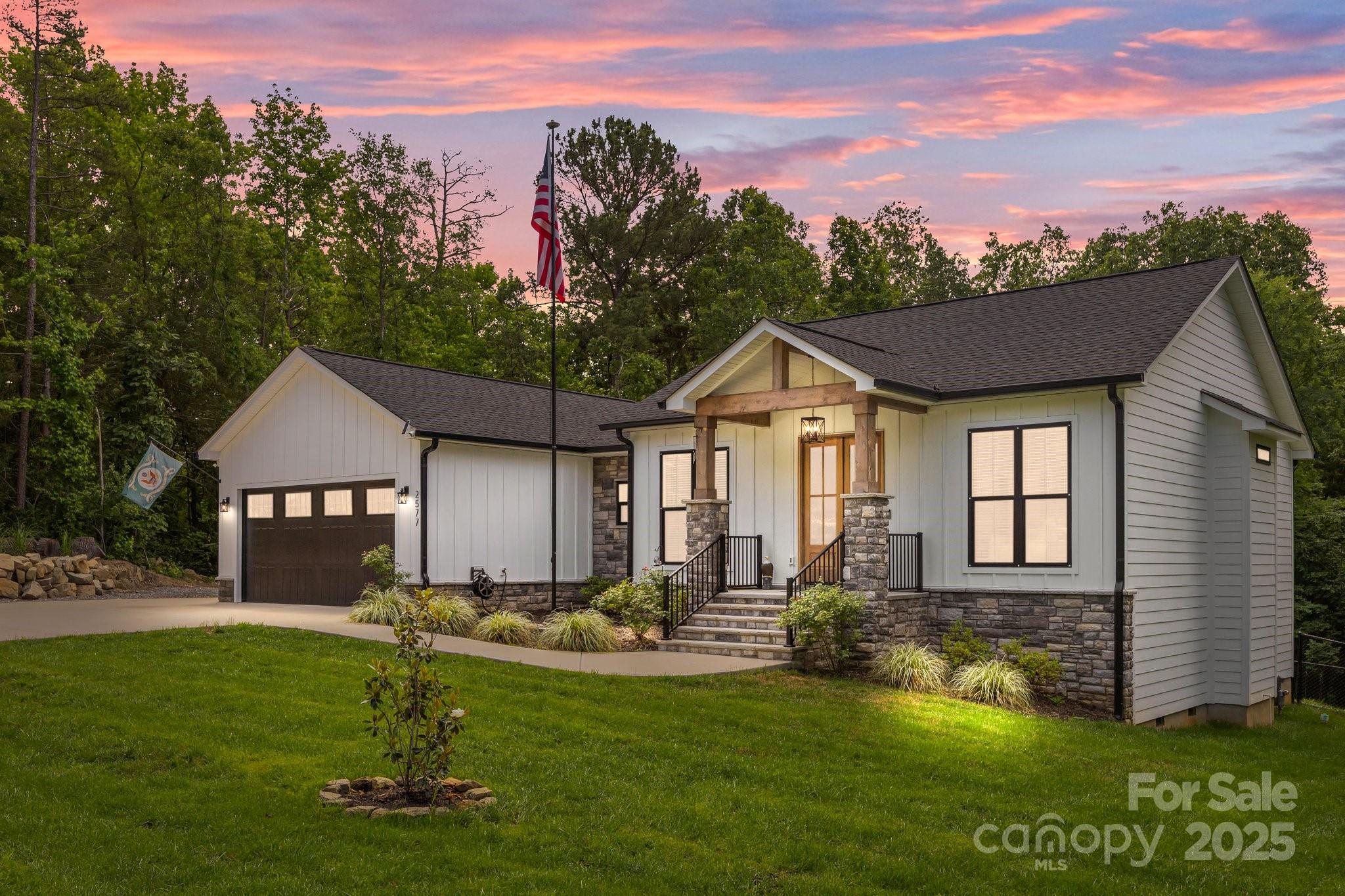 Custom-built ranch on a private 1.2 acre lot where craftsmanship meets modern elegance. From the moment you arrive, you'll be captivated by the sleek black windows/gutters, accented with stonework/wood beams that frame the front porch & double door entry. Step inside to an open-concept layout designed for entertaining & everyday living. The heart of the home is the chef’s kitchen, featuring ceiling-height cabinetry, quartz counters, farmhouse sink, & Cosmo gas range. Butler’s pantry with a beverage fridge & prep area for those who love to host. Split bedroom layout with primary suite tucked away. Indulge in a spa-worthy bathroom retreat. Off the main living area, step through 8-ft double doors into a breathtaking 3-season room with EZE Breeze windows, floor-to-ceiling stone fireplace, wall heater & oversized ceiling fan for year-round enjoyment. The expansive patio offers even more room to relax & entertain, complete with built-in grilling station & hot tub. Large laundry & drop zone.