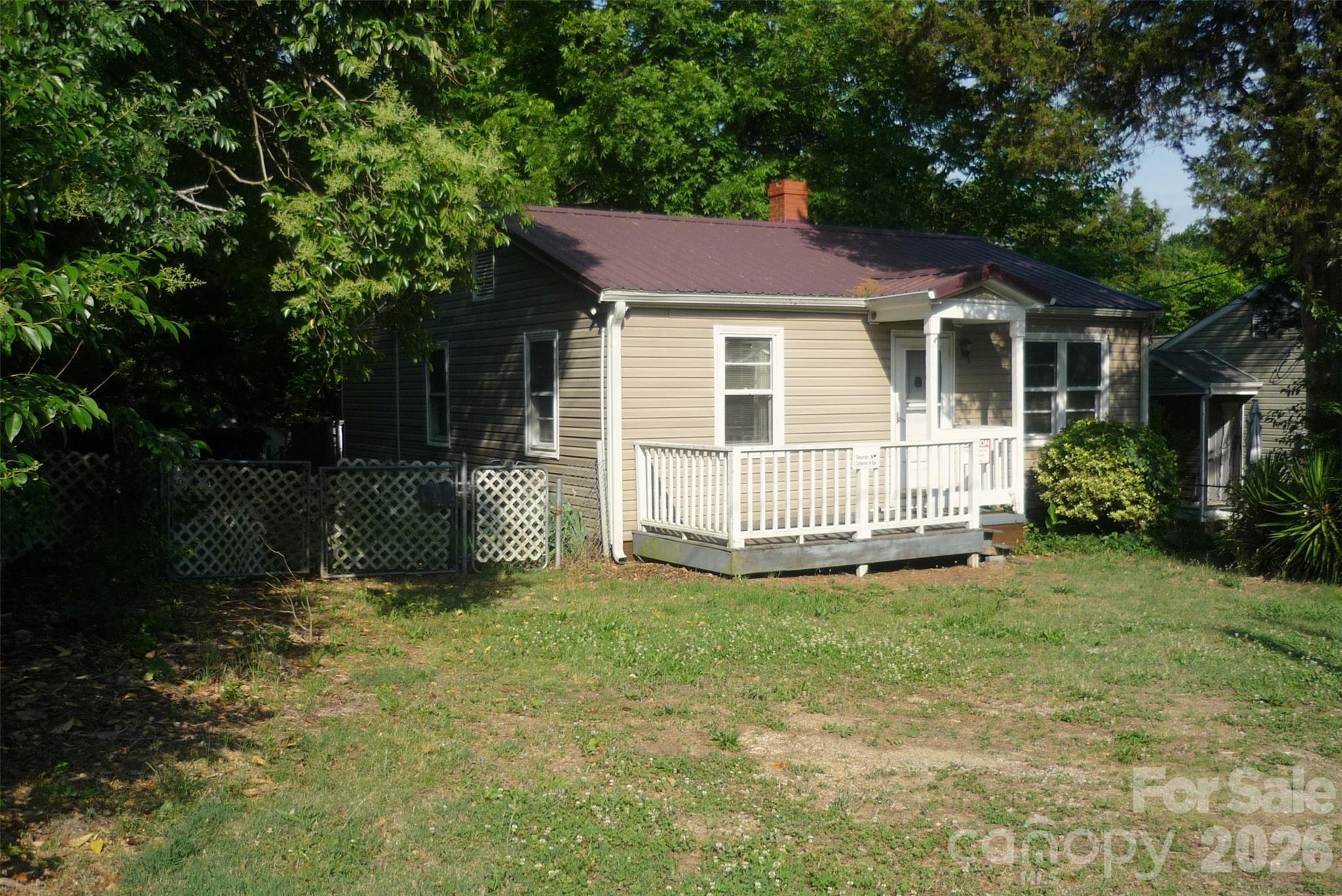 This 2BR fixer upper can easily be a 3BR, 2BA home with the right improvements; The vinyl siding and the metal roof are the only parts of the home that do not need updating / remodeling; Please exercise caution on the quaint front porch and the large rear deck; Wood floors in the home can be refinished; Living room wood stove and also a gas line for a space heater; Kitchen appliances have been removed; Bathroom walk-in shower with a ceramic tile surround; The laundry is located in a large open room in the back of the home with another room off of that; That back room can be broken in to a laundry room, a bathroom and a closet while the back room can be made in to the master bedroom; Attach the closet to the back bedroom and waalaa ... you have a 3BR/2BA home; The fenced back yard has a large shed; The 2 trailers should be leaving the yard soon; The seller has never lived in this property and is selling "as is";