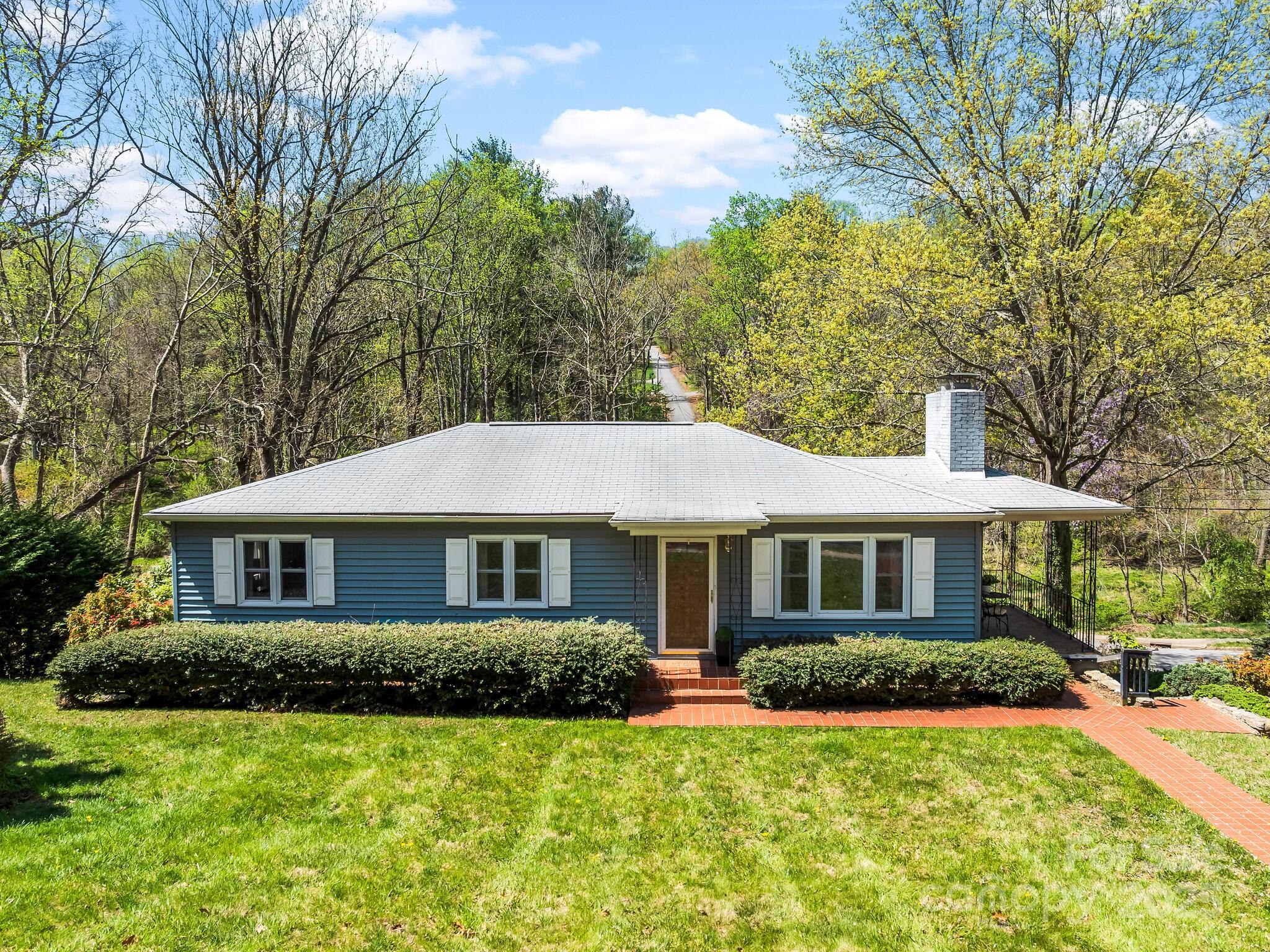 Tucked away in the highly sought-after Malvern Hills neighborhood, this home offers the perfect blend of comfort, convenience, and outdoor enjoyment. Best part - a creek just below the property and not in a floodplain! Situated in an exceptionally walkable community, you’ll fall in love with the nearby green space (just next door), parks, local shops, and West AVL favorites. Enjoy mornings on the covered mosaic tile patio, host gatherings on the back deck, or listen to the peaceful sounds of nature and babbling water. Inside, the home’s unique character shines with a warm, classic feel, with wood paneling & vintage fixtures, yet updated windows. Cozy up by the wood-burning fireplace with a good book, or head down to the basement which offers fantastic flexibility—whether you're dreaming of a rec room, workshop, home gym, or studio, there's room to make it your own. Possibilities for a back yard paradise are endless - offering great potential in a cherished Asheville neighborhood.