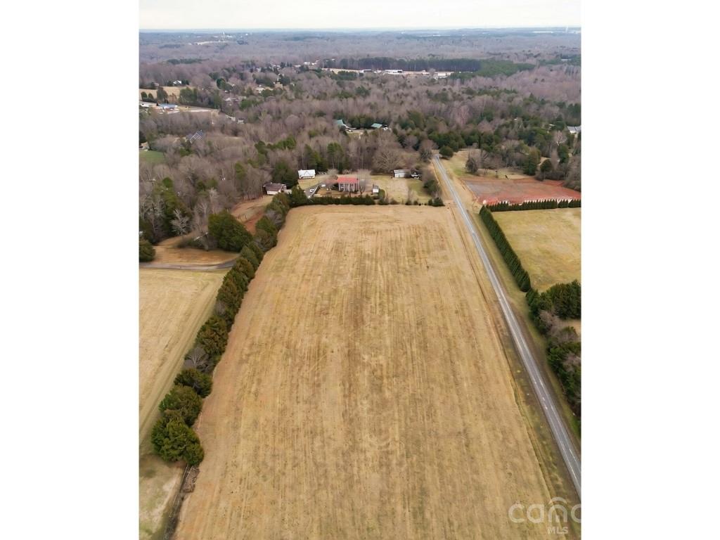 Just 2 miles from I-40, this 10-acre property offers the rare combination of usable land, two homes and convenience. Two parcels provide endless possibilities, whether you're dreaming of a homestead, need space for multigenerational living, hobbies, raising horses or chickens, gardening, storing equipment or simply want the freedom to enjoy private country living. The front 5.98-acre tract is cleared and level with approximately 243 feet of road frontage. The adjoining 4.08-acre tract includes two brick homes, a barn, old farmhouse and sheds. The main home features 5 bedrooms, a main-level primary suite, second ensuite upstairs, 3 garage spaces and basement. The second home includes a living area, kitchen, laundry and unfinished basement. The homes share one septic system. No septic permit is on file, so the second home's living area is not included in the reported heated square footage. Access via Lakey Rd. (private driveway) or Persimmon Dr. (recorded easement) from Greenhill Rd.