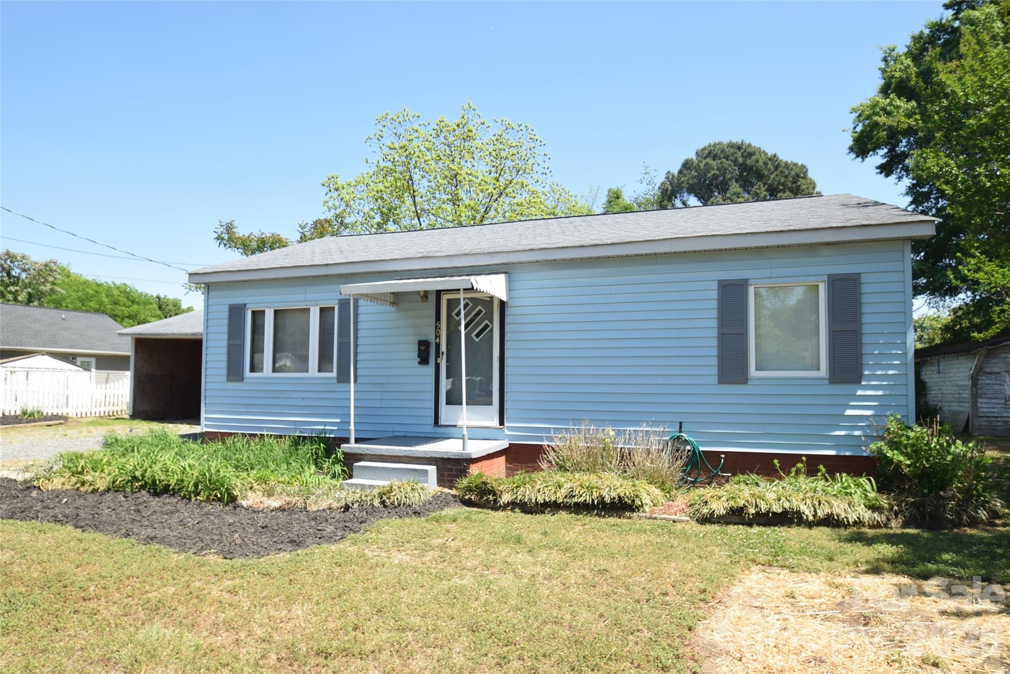Welcome to this beautifully updated ranch home in the heart of Kannapolis! Situated on a generously sized lot, this home offers both comfort and flexibility with a carport that can be utilized for covered parking or removed to suit your needs.  Inside you'll find new laminate wood flooring flowing throughout and a freshly painted interior that creates a bright, move-in ready feel. The home features spacious bedrooms and a newly finished bathroom designed with modern touches.  A standout feature is the versatile den—perfect as a game room, sunroom, or additional living space—offering direct access to the beautiful, flat backyard. Whether you’re entertaining, relaxing, or envisioning future outdoor possibilities, this yard provides the perfect setting.