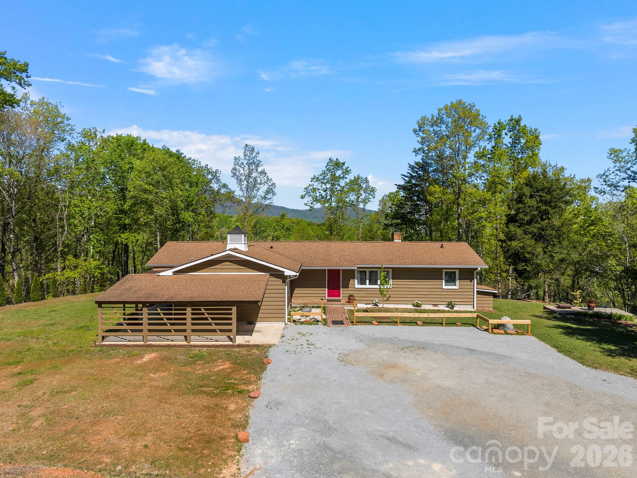 Welcome to a special place in the desirable Persimmon Hill subdivision! Enjoy a scenic year round view from this newly renovated and updated home on a wooded double lot with options to clear for even more views.  There room to include more area for additional gardening and animals.  The home has received an extensive renovation that includes changes to he original floorplan offering  a double primary, including porcelain tiled three bathrooms, a new open kitchen that includes all new appliances, laundry room with washer and dryer, all new Anderson windows with a lifetime transferrable warranty, luxury vinal flooring, wiring, plumbing and so much more!  Original to the  home are the living room built ins and the the focal point of the wood burning fireplace. The sunroom has been converted to heated square footage with the addition of a Hearth Kite 1500 BTU propane wall heater!  The well has had renovation including a new pump and the crawlspace has been encapsulated and has a dehumidifier.  There is plenty of room to add a garage to the home, which was the intent of the Seller while clearing beside the current carport.  The home and septic updates are permitted.  Also note that the outbuilding has multifunctional purpose and has been use for a shop, garage, and storage and could make a wonderful studio or possibly convert to a guesthouse.  The bunker on the property was the original location of the well components which have been redirected to a small addition off the right side of the home.