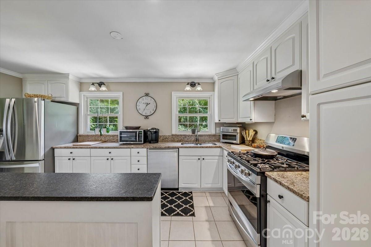 Rare opportunity to own one of South Charlotte's most versatile floor plans. Designed to adapt to a variety of lifestyles, this 5-bedroom, 3-bath home offers a private lower-level living space complete with a separate entrance, separate driveway, 2 bedrooms, full bath, living area, and kitchenette—ideal for multigenerational living, extended family, long-term guests, private home office, or flexible living arrangements. The main level features refinished hardwood floors, fresh interior paint, new appliances, and a spacious layout that lives comfortably as a traditional single-family home. Major updates include a new HVAC system (2025), roof replacement (2022), and extensive electrical upgrades, allowing buyers to move in with confidence. Enjoy the farmhouse-style screened porch overlooking a private backyard retreat, all tucked away on a quiet dead-end street just minutes from SouthPark, the Arboretum, shopping, dining, and major commuter routes. Whether you're looking for room to grow, space to bring family together, or a home that offers flexibility for years to come, 1135 Blueberry Lane is a property with possibilities that are rarely found at this price point.
