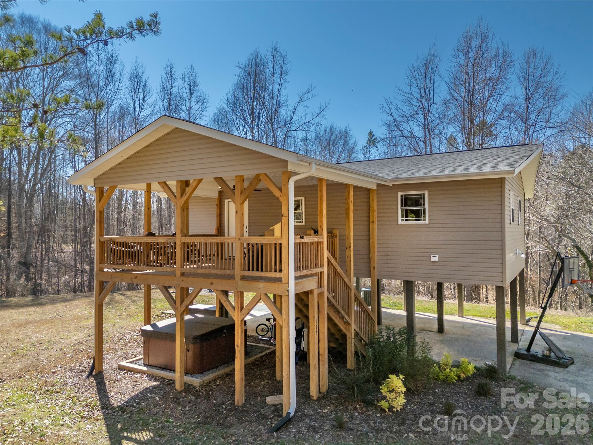 Nestled against a backdrop of beautiful hardwoods, this unique home presents an opportunity for quiet country living just minutes from downtown Rutherfordton.  Situated on 1.28 unrestricted acres, the home is elevated on stilts w/fiber cement underpinning for terrific built-in protected parking or a sheltered spot for entertaining and/or play space.  Large covered deck w/solar lights up the stairs, raised garden boxes & fruit trees, firepit, powered outbuilding, and like new hot tub.  What's more, the builder gave significant forethought into how the home might expand in the future.  Plumbing & electrical were stubbed in downstairs so that the space could later be enclosed, plus the deck was constructed to structurally support added living area.   Multiple options for more heated square footage, storage or even a workshop!  Open concept layout w/efficient U-shaped kitchen, gorgeous stainless appliances & granite countertops.  Vinyl plank flooring throughout and adult-height vanities in both baths.  Truly an adorable home that is solidly constructed and MOVE-IN READY.