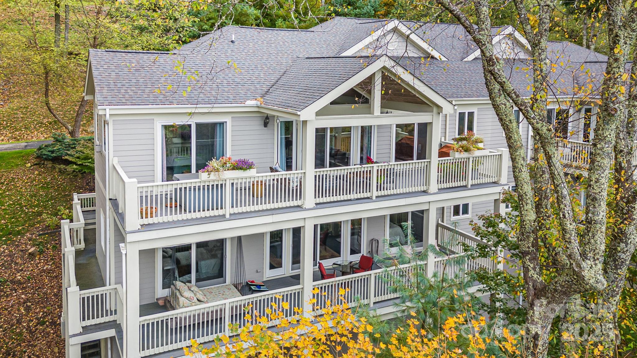 Experience refined mountain living at 4,500 feet elevation in this turnkey 5-bedroom, 3.5-bathroom fully furnished Mountainside Townhome inside the gates of Wolf Laurel Resort—a private, year-round, gated mountain community less than 35 minutes from Asheville, Johnson City, Burnsville, and Weaverville. Resort-style amenities are within walking distance, including the Wolf Laurel Country Club, Fitness Center, and Golf Course.

Offering 3,199 sq ft of beautifully finished living space with four fireplaces, an attached two-car garage, and two expansive 488 sq ft decks—one featuring a hot tub and the other a swing bed—this residence combines high-elevation comfort with luxury design. An additional 845 sq ft unfinished basement with 12’8” ceilings offers exceptional potential for expanded living space or an impressive wine cellar.

The entrance level features a welcoming living room, kitchen, and dining area, along with the primary suite, which includes an en-suite bath, two closets, and direct access to the main deck overlooking panoramic long-range mountain views.

Upstairs, the second level offers another living area, a second bedroom with en-suite bath, and a third bedroom with a full bath for family or guests. Two large bonus rooms add valuable flexibility—one currently used as a media and office space, and another as a private workout and music room. Both could serve as additional bedrooms, hobby spaces, or multipurpose flex areas, offering versatile options for future owners. The second level also provides access to the upper deck from three rooms, where the swing bed invites you to unwind and enjoy cool mountain breezes.

The gourmet kitchen features premium appliances, including a SubZero refrigerator/freezer, WOLF gas range and oven, and dual BOSCH dishwashers. A steam shower, updated lighting, and fine finishes throughout add a touch of understated luxury to this move-in-ready home.

This end-unit townhome enjoys exceptional privacy, with no neighbor on one side, and the property extends to the cul-de-sac. Step onto your decks to enjoy all-season mountain views—spectacular in winter, lush in summer, and vibrant during fall foliage. The attached two-car garage provides secure parking and extra storage—another rare and valuable feature within Wolf Laurel’s mountain terrain. Connected to community sewer service, a rare amenity in Wolf Laurel where most homes rely on septic systems, this property offers low-maintenance convenience and long-term value.

Outdoor enthusiasts will love the home’s direct access to the Wolf Laurel Nature Trail, which connects to the Appalachian Trail just a short walk away, plus miles of biking and hiking trails throughout the resort. The upcoming Hatley Pointe Adventure Bike Park, opening in 2026, will further enhance the area’s appeal to cyclists and adventurers.

The Wolf Laurel Country Club is a private, member-owned club featuring a world-class chef, full bar, and extensive wine list, offering fine dining with breathtaking mountain views. The resort provides year-round recreation including Hatley Pointe Ski Resort, golf, tennis, heated seasonal pool, pickleball, stocked trout pond, hiking, and equestrian facilities, all surrounded by thousands of acres of protected wilderness and Pisgah National Forest. The home’s proximity to Hatley Pointe’s Smoke & Timber Restaurant—just a short drive inside the gated Wolf Laurel Resort community—provides convenient, year-round dining and a welcoming gathering place for residents and visitors alike.

Whether you’re seeking a primary residence, vacation retreat, or income-producing investment, this Mountainside Townhome at 4,500 feet elevation delivers an unmatched combination of luxury, location, and high-elevation adventure within one of Western North Carolina’s most desirable gated communities.