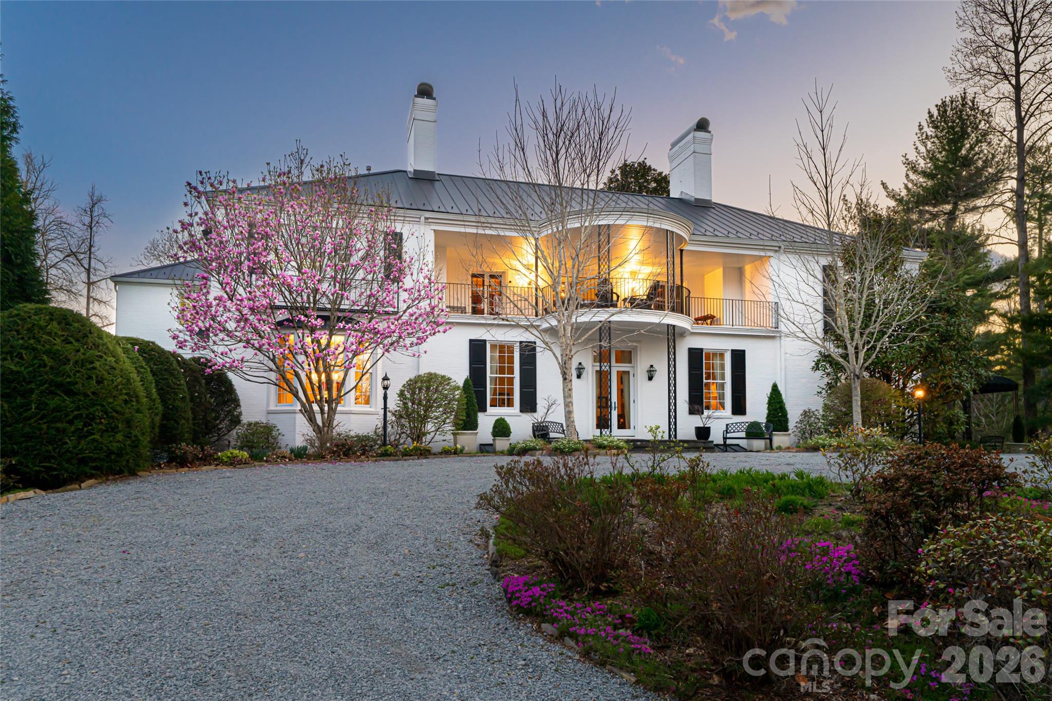 In the storied heart of Flat Rock lies Hopewood, an extraordinary estate that blends timeless elegance with welcoming warmth. Set on nearly six acres of formal gardens, private courtyards and tranquil retreats, this rare property is a Southern treasure. Originally commissioned in 1938 by Reuben B. and Hope Thomson Robertson, the residence was designed by their nephew, James Gamble Rogers II, a distinguished architect trained at the École des Beaux-Arts in Paris. The Robertson family’s legacy is deeply entwined with the history of Champion Paper, the Great Smoky Mountains National Park and Asheville itself, giving Hopewood a provenance as rich as its beauty. Approached beneath a canopy of trees, the main home opens through the original solid cherrywood door into a grand foyer, where a sweeping staircase and quarter-sawn oak floors laid in elegant patterns set the tone. Gracious living and dining rooms, each with wood-burning fireplaces, showcase high ceilings, plaster walls and fine wainscoting, while the loggia, with its terrazzo floors, leads to a Japanese-inspired stone-walled garden. A temperature-controlled wine room, handsome library with fireplace, and bright en-suite guest room complete the main level. At the heart of the home, the thoughtfully updated kitchen features a Sub-Zero refrigerator, Wolf six-burner range, expansive island and adjoining casual dining space that flows naturally to the outdoor terraces. An entertainment pantry with a secondary dishwasher and beverage cooler elevates gatherings, while a hidden elevator connects all levels with ease. Upstairs, a spacious library, two porches and two additional en-suite bedrooms offer refined comfort. The primary suite impresses with vaulted ceilings, dual dressing rooms, a spa-like bath and a morning bar. Original details, from preserved moldings to artisan light fixtures, are complemented by sensitive updates that respect the home’s history while enhancing livability. The estate’s grounds are equally captivating. Formal boxwood gardens, cutting beds and a heritage Japanese maple (imported in the 1890s) create a horticultural tapestry of rare beauty. Meandering paths lead to a stone fire pit, a garden pavilion and tranquil lawns designed for outdoor entertaining. Two charming guest cottages, one with two bedrooms and two baths, the other with two bedrooms, a full bath and half bath, add versatility for hosting, caretakers or extended family. In total, the property encompasses seven bedrooms, six full baths and two half baths. Hopewood is more than an estate, it is a living legacy. Lovingly stewarded through generations and protected by preservation easement, it embodies the enduring spirit of Flat Rock, where history, nature and refinement meet in one of the South’s cherished settings. Seller offering finance options.