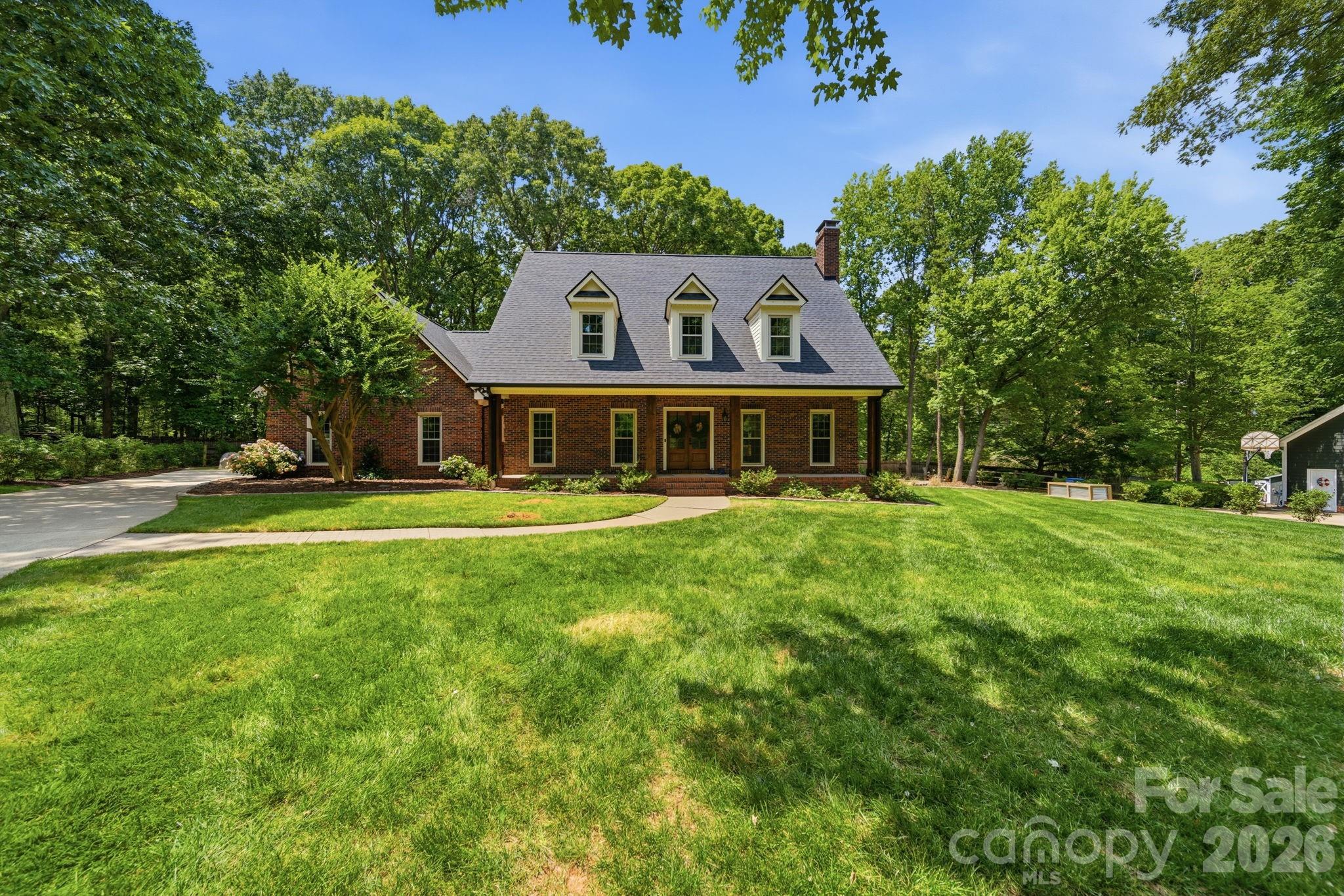 Back on the market after newly installed roof, this newly renovated all brick home features top to bottom all white oak hardwood floors with approximately 3000 ft.² of living space to make you feel right at home. The front porch, newly designed back deck and fully irrigated yard leading to the open fire pit will be the first thing you notice about this property; making for memorable gatherings. With an easy commute to downtown Charlotte, minutes from downtown Matthews and Mint Hill and walking distance from newly opened Ezell Farms Community Park, you could not ask for a better location. Step inside to find this 3 bedroom, plus 2 additional finished rooms that could function beautifully as a guest room, office or workout space providing the flexibility of a 5 bedroom layout.The primary suite is located on the main floor featuring a luxurious updated bath designed not only for relaxing, but also helpful for smooth mornings and evenings. The heart of the home is the open layout of the kitchen and living room complete with KitchenAid appliances, making everyday meals and entertaining feel effortlessly enjoyable. Sellers are also including a $5,000 seller paid concession at closing with a strong offer.