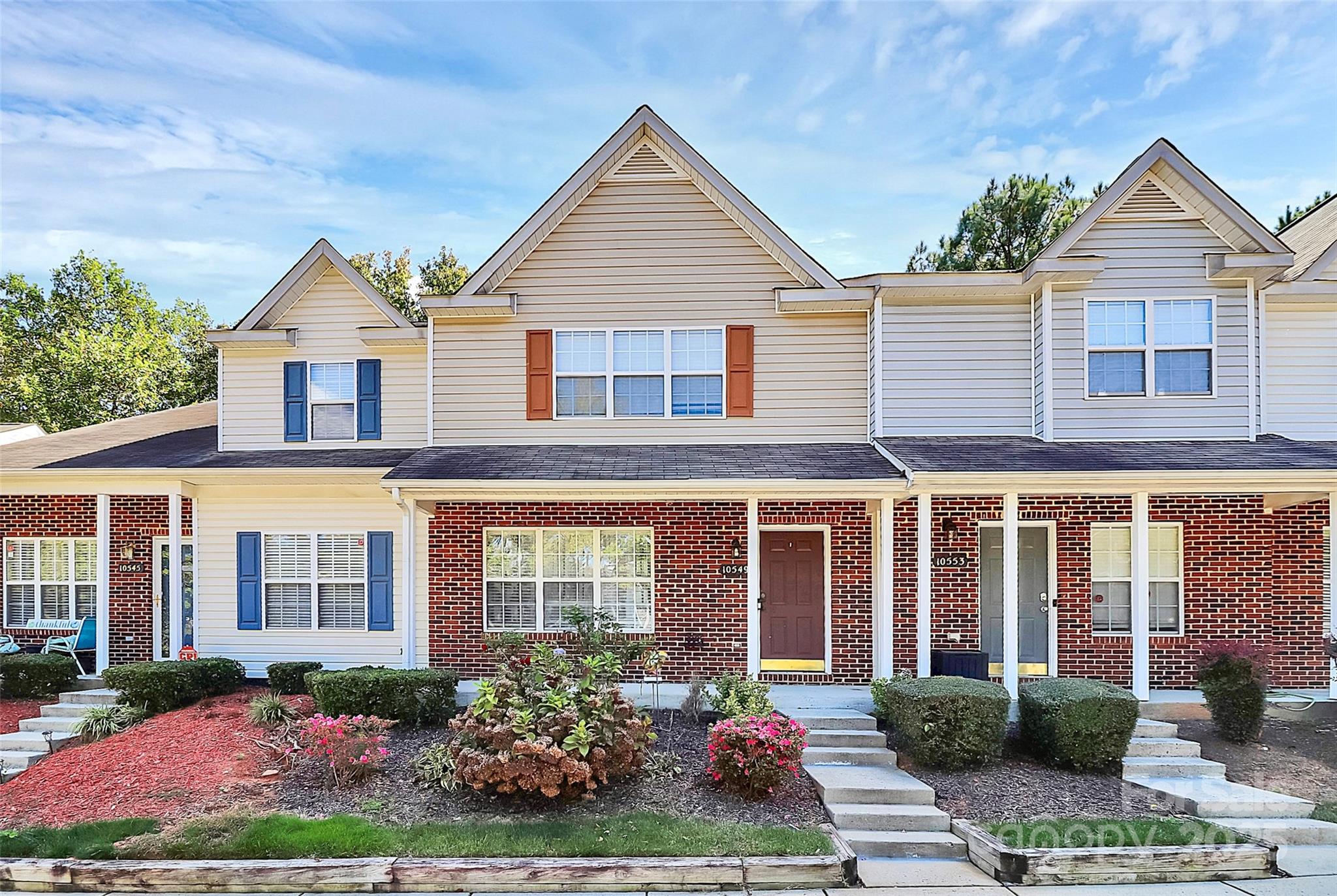 Welcome to Hunter Downs and this stunning town home!  This amazing home has a lot of bonus features!  As you walk up the front steps to this partial brick home you will see the rocking chair front porch that is perfect for relaxing.  As you walk into the living room, the gas fireplace is the highlight of this well lit open area.  With lots of room for seating and plenty of room for the dining area this is a great entertaining area.  All of this leads into the spacious kitchen complete with stainless steel appliances, counter space and an eat in area.  Enjoy dining al fresco off the elevated back porch.  Near the large pantry is the half bath and the large laundry room.  Upstairs are two bedrooms, both set up like a primary bedroom with their own private bath and walk in closet.  The vaulted ceilings make them feel large and airy.  This is a great set up for roommates.  The lower level adds a lot of value with a large family room, private bath and another bedroom opening out to the patio.  Lots of opportunity for a personal home or investment property.  The community boasts lots of sidewalks and an outdoor pool located at 9535 Terrier Way.  All of this and more just minutes to 85, 77, Northlake Mall and more!  Plenty of dining and shopping all around the community.  Low HOA dues and a great location! Take a look today!