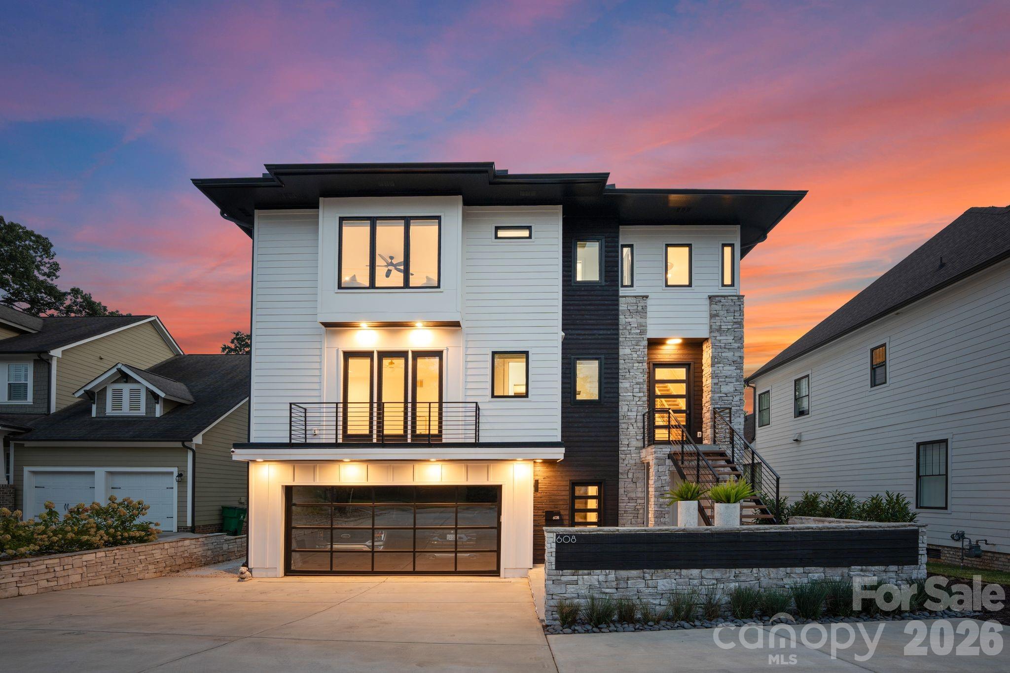 Defined by premier amenities, seamless indoor-outdoor living, and resort-style features, this exceptional custom residence offers elevated luxury in one of Charlotte’s most coveted and walkable locations. Complete with a private pool, expansive entertaining spaces, and two serene primary suites, the home is perfectly positioned between South End and Dilworth, placing the best of the city just outside your door.

From this ideal setting, enjoy effortless walkability to South End’s celebrated restaurants, breweries, boutiques, cafés, and the Rail Trail, along with easy access to Dilworth’s charming streets and neighborhood favorites. Uptown is minutes away, with walkable access to Bank of America Stadium for Panthers games, concerts, and major events, while Charlotte Douglas International Airport is conveniently close for stress-free travel.

Inside, a light-filled open floor plan connects the living, dining, and kitchen areas, designed for both everyday living and elevated entertaining. The chef’s kitchen features a striking waterfall soapstone island, quartz countertops, professional-grade appliances, and a butler’s pantry. The dining area opens seamlessly to a main-level patio through a dramatic glass garage-style door, creating a true indoor-outdoor experience.

The main level hosts a serene primary suite with a spa-inspired bath, custom walk-in closet with integrated laundry, and an adjacent sitting room ideal for a home office or private breakfast space. Upstairs, a second expansive primary suite is joined by two additional guest bedrooms, a Jack-and-Jill bath, and a full laundry room. The lower level offers an entertainer’s retreat with a media wall, kitchenette, sauna, guest suite, and direct access to the backyard.

Outdoors, a resort-style oasis awaits with a pool featuring water elements and LED lighting, a dedicated grilling station, and expansive patios designed for gathering. Thoughtful details, high-end systems, and refined finishes throughout make this home a truly rare offering in a premier Charlotte location.