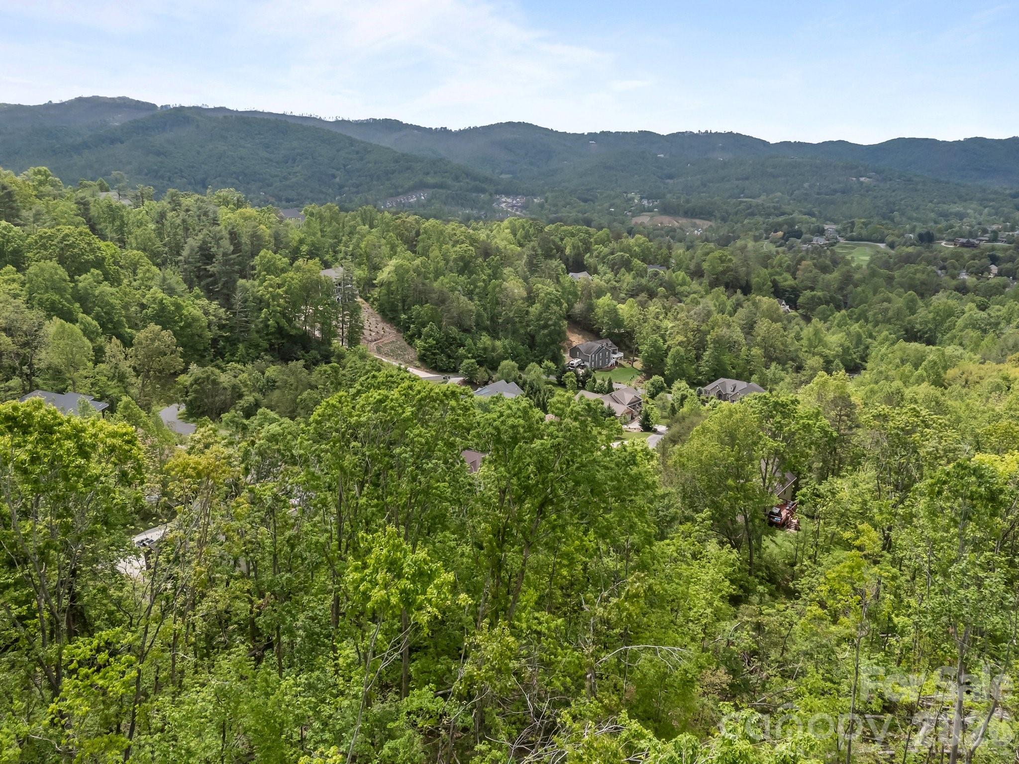 Discover your dream homesite in the prestigious Reems Creek Golf Community.
This exceptional 2.7-acre, south-facing homesite offers breathtaking, year-round panoramic views of the Blue Ridge Mountains—a truly rare find in Weaverville.
While the property presents a dramatic slope at first glance, it offers excellent buildability with multiple potential building sites. The natural topography is ideal for a custom mountain home with a walkout lower level or terraced design, and notably, the higher up the lot you build, the more expansive and dramatic the long-range mountain views become. This elevation advantage allows for thoughtful site placement that maximizes both privacy and scenery.
The southern exposure provides an ideal setting to maximize natural light and passive solar design, enhancing energy efficiency and everyday comfort. Enjoy the peaceful, upscale atmosphere of this sought-after golf community, just minutes from Weaverville and Asheville.
City water, sewer, natural gas, and underground power are available at the road, helping streamline the building process and reduce infrastructure costs.
A rare opportunity to build in one of the area’s most desirable neighborhoods—where elevation, buildability, and unmatched mountain views converge.