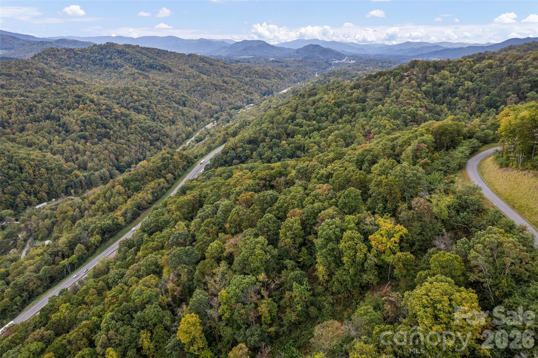 Breathtaking Southern Exposure & Panoramic Mountain Views on 15+ Acres in The Summit of Asheville. Discover your private mountain escape on over 15 acres of pristine forest land, perfectly situated in the prestigious gated community of The Summit of Asheville. A primary residence PLUS two guest houses are allowed on this lot. With full southern exposure and sweeping long-range views of the Blue Ridge Mountains, this homesite offers an unmatched blend of natural beauty and modern convenience. Located just 10 minutes from vibrant Asheville and 20 minutes from charming Waynesville, you’ll enjoy easy access to top area attractions, outdoor adventures, and everyday essentials. Positioned to capture dramatic views toward the Blue Ridge Parkway, this lot promises vistas that are truly hard to beat. Enjoy paved road access all the way to the property, and underground utilities already in place. The community features scenic hiking trails, peaceful waterfalls, and a serene mountain setting — all just a short drive from the city. Don’t miss this rare opportunity to build your dream home in one of Western North Carolina’s most sought-after communities.