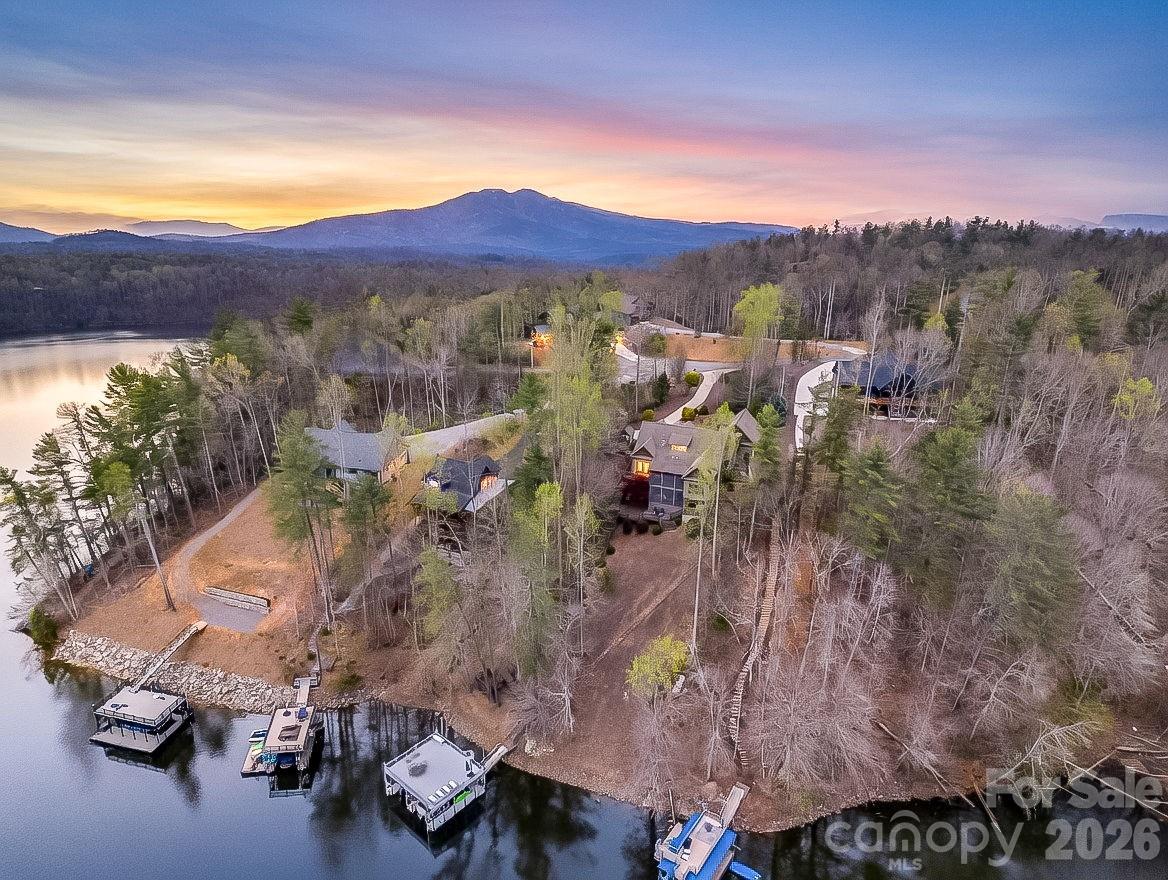 Whether you decide to reside full time, or create your own mountain retreat, this high-quality craftsman home exceeds expectations. Custom woodwork, cathedral ceiling with towering stone fireplace, light filled expansive windows, gourmet kitchen and impressive primary suite enhance this home's appeal. The kitchen provides a six-burner gas Wolf range with pot filler, Wolf double wall ovens, Sub- Zero refrigerator and wine cooler. The bright sunroom will entice you to sit for a spell. Enjoy company by the fireplace in the great room. Primary suite offers a beautiful soaking tub, tiled shower and custom walk-in closet. Fully screened porches on the main and lower levels provide alfresco space to entertain and cook on the grill. The basement level offers a spacious den, billiard/game room, three guest rooms and two full bathrooms, along with a screened porch, deck and hot tub. Additional guest bedroom or office is privately located above the garage and includes a full bath. The exterior sun deck provides lake views, floating dock, double boat lifts and upper-level sun deck. Lake James is sourced from mountain rivers providing pristine water for swimming, kayaking, skiing, fishing and so much more.  Framed by the Linville Mountain Gorge, this lake offers breathtaking serenity. Life is better on the lake! 
*Home includes a rare and coveted tram incline system providing easy lake access for you and your boating supplies down to the boat dock.
*Sold substantially furnished; Buyer's choice of 2016 Chaparral 21 H2O Bowrider 225hp inboard/outboard; OR 2016 Stratos 186 Bass boat 115hp Mercury Optimax, with trolling motor.