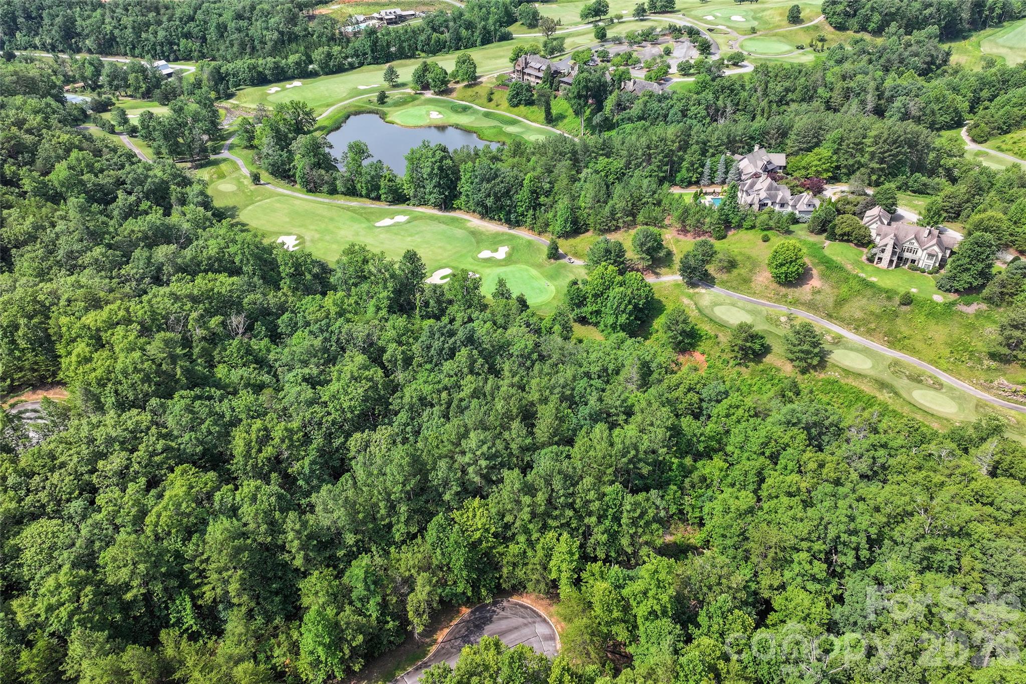 Build your dream home in the resort-like gated mountain community of Brights Creek, where luxury amenities and natural beauty create an exceptional lifestyle. This private 1.08-acre, end-of-cul-de-sac homesite offers a gently sloped building site with golf course and mountain views, plus the convenience of paved roads, fiber-optic internet, natural gas, public water and sewer. Residents enjoy a 24-hour staffed gatehouse and miles of scenic recreational trails, including a beautiful waterfall trail. With membership, experience the renowned 19-hole Tom Fazio Championship Golf Course, tennis and pickleball, extensive equestrian facilities with barn, outdoor arena and miles of scenic riding trails, plus The Mill at Brights Creek featuring a heated saline pool, fitness center, casual dining, full bar, bowling alley and inviting gathering spaces. Ideal for avid golfers, equestrian lovers or anyone just looking to be surrounded by nature with all the perks of a luxurious gated community with world-class amenities.