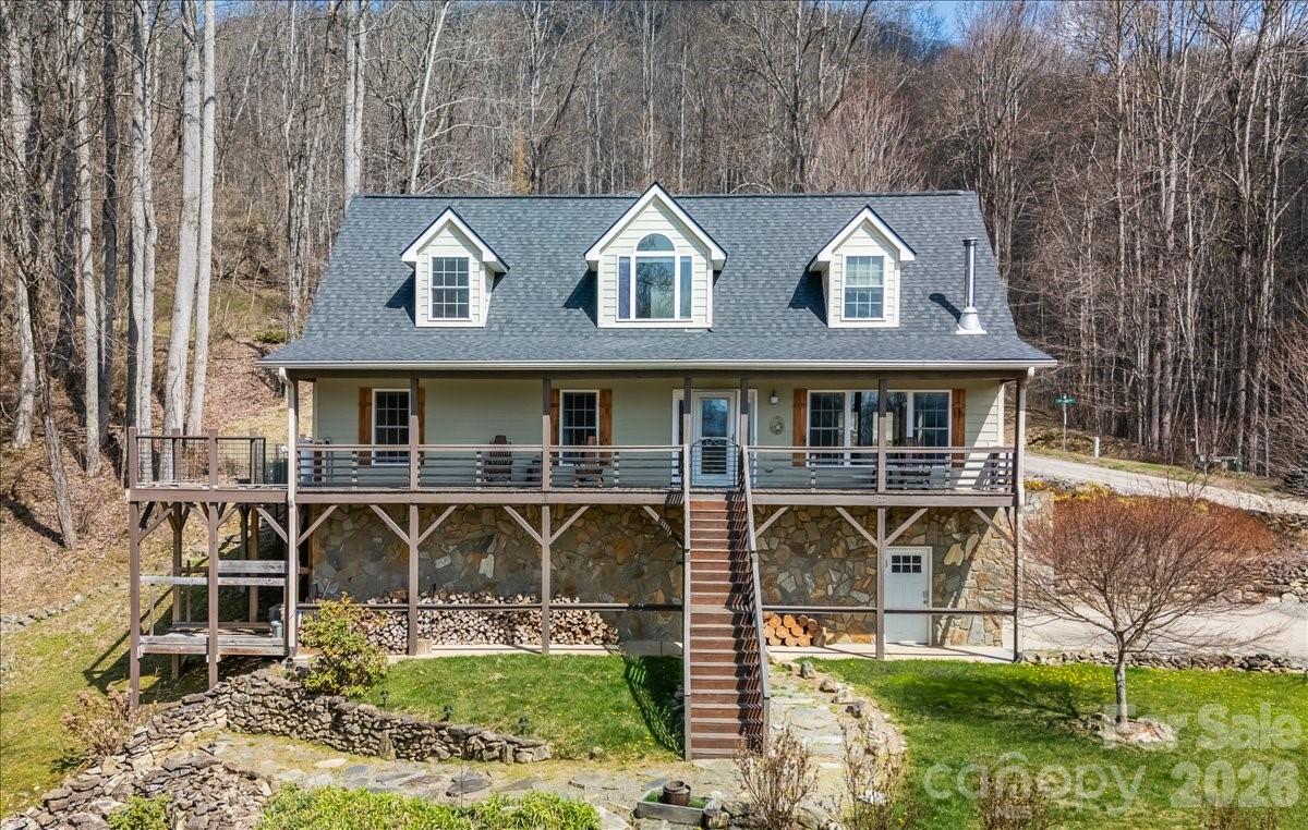 UNIQUE MOUNTAIN PROPERTY! Privacy/Mountain Views/Expansive Usable Yard/Oversized Garage w/4-Car Capacity-Workshop/Rolling Pastures/Close Proximity to Waynesville/Maggie Valley. 

Contact The Cabin Fairy For Your Personal Tour!
Tucked within a serene gated community, this enchanting 3-bedroom, 2-bath retreat rests gracefully on over 3 private acres with a new roof, whole-house water filtration system, outdoor hot tub and authentically designed mountain firepit — where nature, comfort, and quiet luxury come together in perfect harmony.

A gently cascading mountain stream winds through the property, creating a peaceful, ever-present soundtrack that elevates both everyday living and guest experiences. With well-maintained roads guiding you home and a level upper driveway entry, access is as effortless as it is inviting.

Inside, the main level unfolds with an open-concept kitchen, living, and dining area anchored by a charming wood stove designed for cozy evenings and memorable gatherings. The primary suite, second bedroom, full bath, and laundry are thoughtfully positioned on this level for ease and functionality.

Upstairs, a spacious open-concept loft offers incredible flexibility, ideal as an additional sleeping area, creative retreat, or lounge space. Expansive fixed-glass windows frame tranquil views of the flowing mountain stream, bringing the outdoors in and filling the space with natural light.

The oversized basement garage provides generous room for storage, workshop use, or additional potential. Seasonal winter views enhance the sense of privacy, offering a layered mountain backdrop that shifts beautifully throughout the year.

Offered fully furnished, this property is not only move-in ready, it’s also turnkey for continued success as a short-term rental, blending investment potential with the signature charm of a Cabin Fairy-approved escape.

A place where ease meets enchantment, and every detail invites you - or your guests - to stay just a little longer.