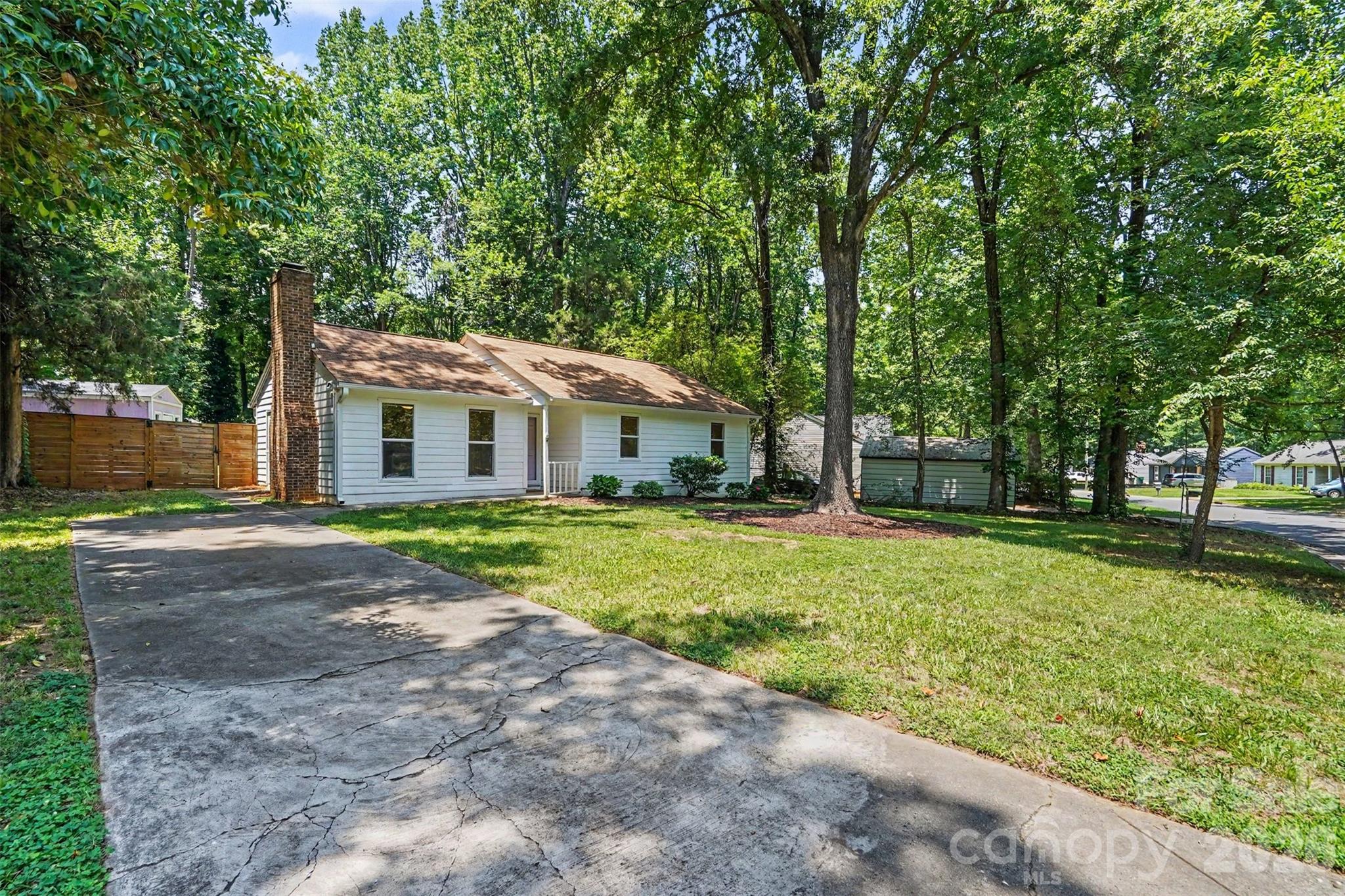 Welcome to 5301 Great Wagon Road, where modern updates, timeless character, and an unbeatable location come together in one exceptional property. Situated in the quiet Alexander Place community with no HOA, this beautifully renovated 3-bedroom, 2-bath home has been thoughtfully refreshed and meticulously cared for, offering true move-in-ready convenience. Step inside to an inviting open floor plan designed for both everyday living and effortless entertaining. The spacious living area, dining space, and kitchen blend seamlessly together, creating a warm and welcoming atmosphere. Recent improvements include new flooring throughout, fresh paint, updated trim, and a stylish kitchen featuring stainless steel appliances. A charming wood-burning fireplace serves as the centerpiece of the living room, adding warmth and character to the home's contemporary finishes. Outside, the beautifully landscaped 0.31-acre lot offers a backyard that feels like a private retreat. Surrounded by mature landscaping and fully fenced, this outdoor oasis is ideal for hosting family and friends, enjoying quiet evenings, or letting pets play freely. A large storage shed provides plenty of room for lawn equipment, tools, and seasonal storage. Conveniently located just 15 minutes from Uptown Charlotte and only 10 minutes from the vibrant restaurants, breweries, shopping, and entertainment of Plaza Midwood and NoDa, this home delivers the perfect combination of peaceful neighborhood living and easy access to everything the city has to offer. With tasteful renovations, a functional layout, exceptional outdoor space, and a location that puts Charlotte's most popular destinations within easy reach, 5301 Great Wagon Road is ready to welcome its next owners home.