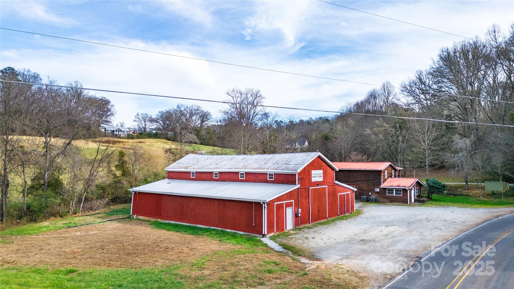 **Great Opportunity!** This property features a spacious 70x62 barn and a charming 2-bedroom, 2-bathroom house situated on 1.33 +/- acres. Both buildings have undergone numerous upgrades. The house includes a newer HVAC system, several replaced windows, and the septic system was pumped last summer. The barn boasts whole-barn spray insulation, a new exhaust fan, insulated roll-up doors, and 220V electrical service for auto lifts. Additionally, an office area with fitting rooms and a new half bathroom has been constructed on the left side of the barn. Recent barn improvements include added gutters, new fascia boards, and drainage lines. A French drain was installed to divert water from the road to the creek. This setup is ideal for someone looking to live on-site while keeping storage items accessible. The barn, thought to be built in 1960, has water and power hook ups for an RV. It also has potential for rental opportunities. The house is currently rented. Please provide 24 HOUR NOTICE TO SHOW.