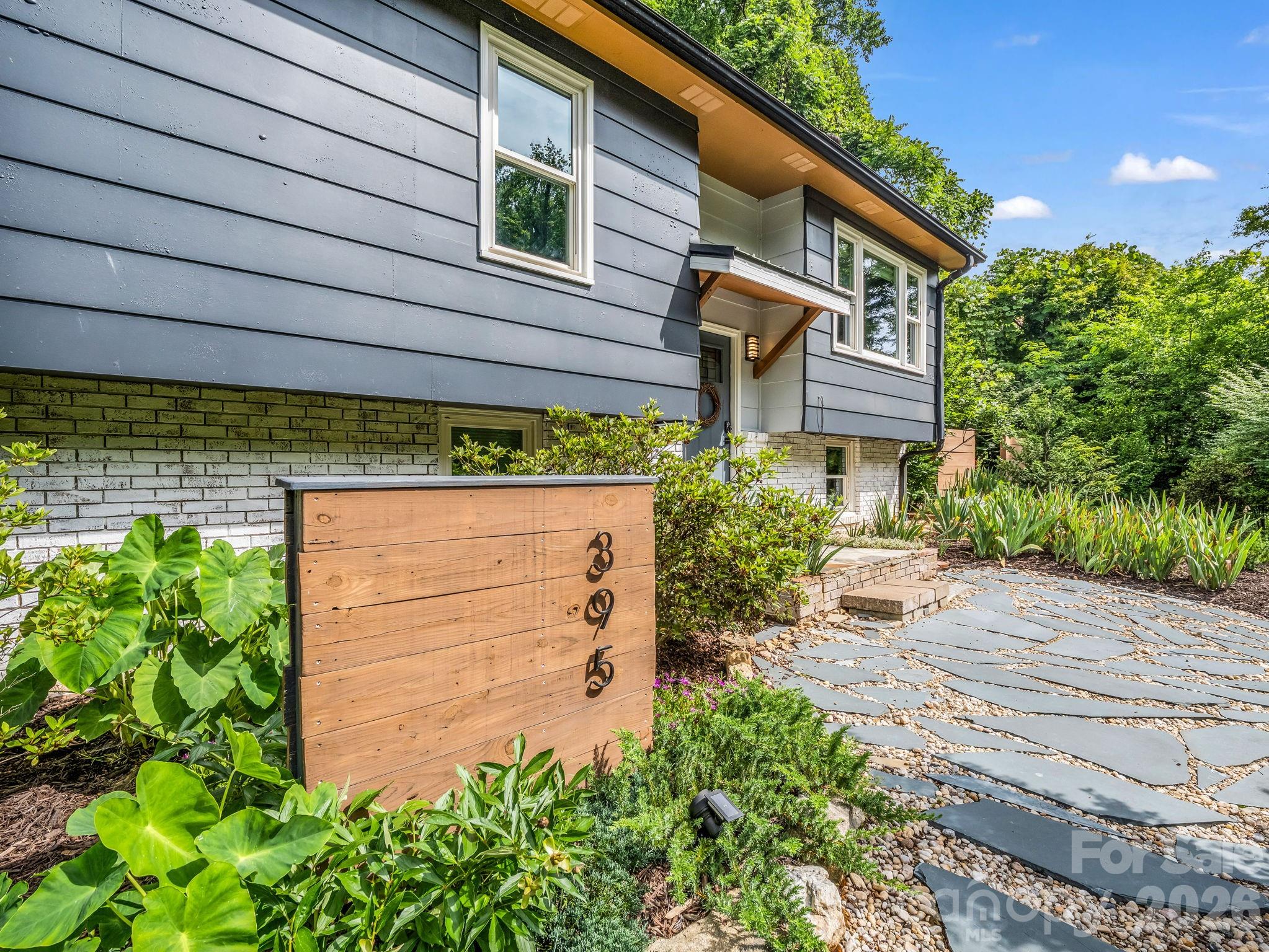Fully remodeled and move-in ready, this thoughtfully restored, mid-century modern home blends updates with timeless charm near downtown Tryon. Permits were pulled during the renovation, including plumbing and electrical. Features include soft-close cabinetry, granite countertops, new flooring, fresh interior paint, newer windows, paid-off solar for added efficiency, a new drainage system, newer gutters, and a new garage door with motor.

The main living area offers a cozy wood-burning fireplace and an easy flow for everyday living or entertaining. Outdoor spaces are a standout, with patios, stonework, an outdoor fireplace, and a BEAUTIFUL covered side porch accessed through striking new doors (through the bedrooms). The kitchen is both functional and inviting with updated finishes throughout. (bright, fresh, clean!)

The spacious primary suite features a large walk-in closet and a showstopping renovated bathroom. Bonus space offers flexibility for a home office, guest area, playroom, or potential future bedroom conversion. (plus storage room!)

Located just a short walk to downtown Tryon, enjoy the charm of this beloved mountain town known for horse country, scenic beauty, local shops and restaurants, and access to the future Saluda Grade Trail. A rare opportunity to enjoy a fully updated home in an ideal Tryon location.