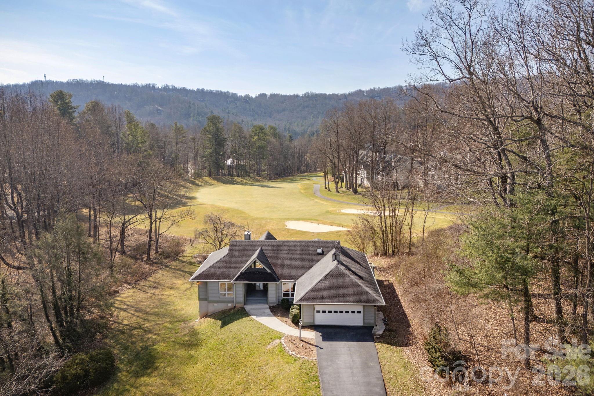 Rare golf - course home in Kenmure that overlooks 15th green and long fairway. Mountain views, private location. Outstanding floor plan for easy living and entertaining. Wall of windows in great room lets in lots of natural light. Property boasts lovely screened porch and outdoor living opportunities. At the heart of the home is a chef’s kitchen designed for entertaining, custom cabinetry, upscale countertops and premium appliances. Retreat to the home office—a serene space for creating or peaceful reflection. The terrace level offers a large family room with bar, guest space with fantastic views, plus a crafts room/flex space. Whole-house Generac Generator.Unique private setting, level driveway and amazing views! Newer generator, HVAC system, and water heater. Prime location! Property is NOT part of Brookwood Village condo association. Home was built on estate lot and offers significant golf course frontage.