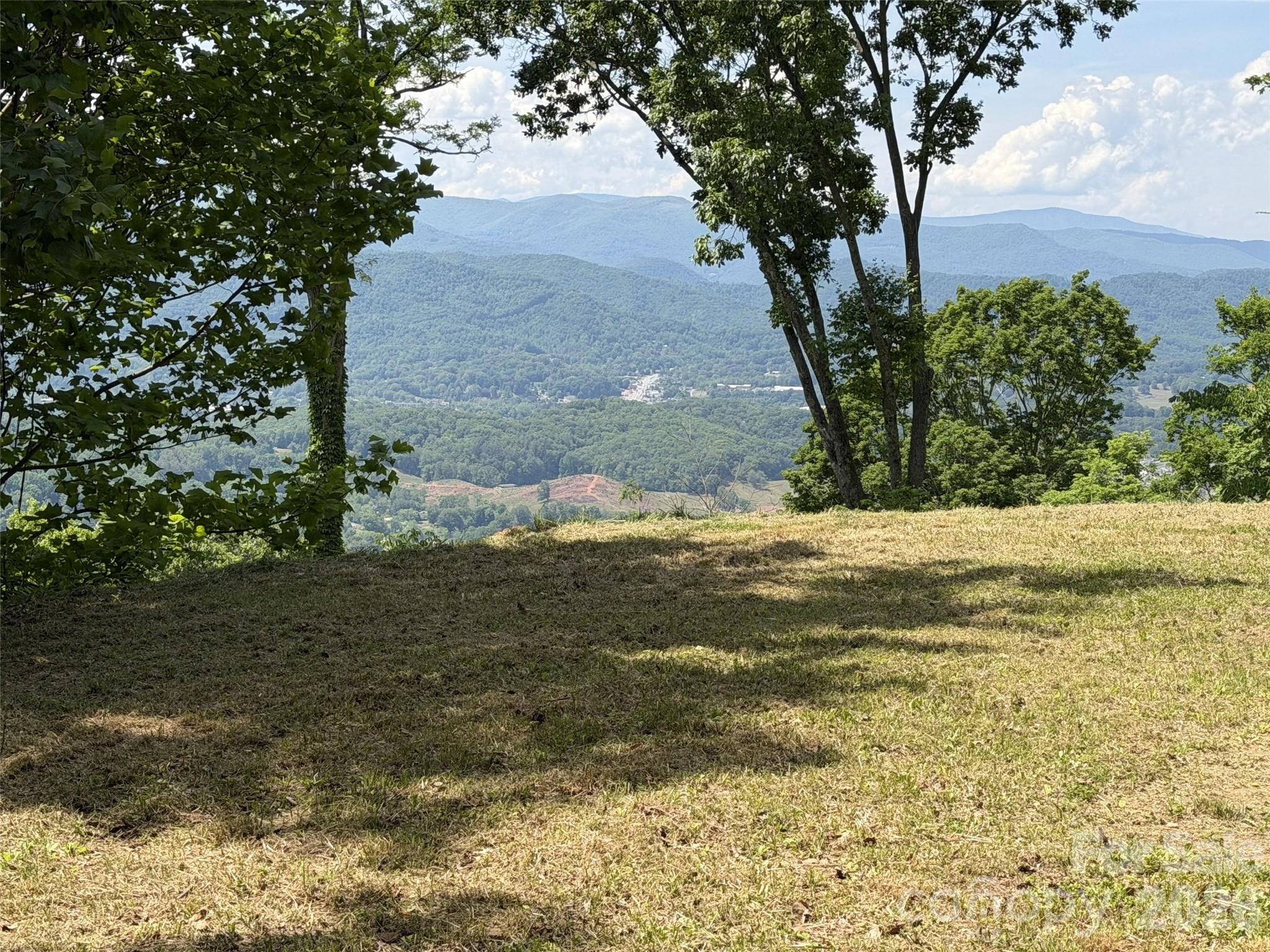 Discover the perfect blend of privacy, natural beauty, and convenience with this exceptional 10-acre parcel just minutes from downtown Waynesville. Tucked away in a serene setting that offers a remarkable sense of solitude, the property is only a five-minute drive from the base of the neighborhood to the charm of Historic Main Street. A driveway and homesite are already in place, along with valuable infrastructure including underground power, a newly drilled well (pump not yet installed), and an installed septic system—saving significant time and cost as you
plan your mountain retreat. The property will boast incredible views from the home overlooking Waynesville and its sweeping long-range mountain vistas beyond—a truly breathtaking backdrop for your future home. Accessed through a gated development, just beyond the development itself. With its stunning setting, unmatched privacy, and so much groundwork already completed, this property presents the rare streamlined opportunity to create your idyllic WNC retreat.