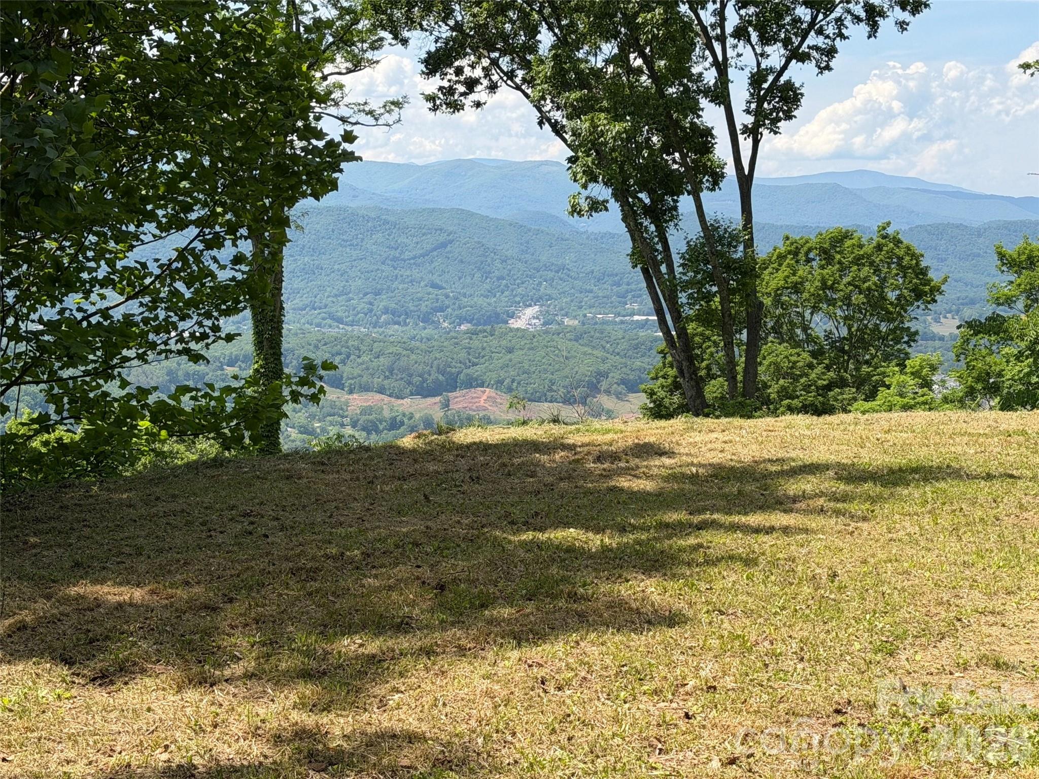 Discover the perfect blend of privacy, natural beauty, and convenience with this exceptional 10-acre parcel just minutes from downtown Waynesville. Tucked away in a serene setting that offers a remarkable sense of solitude, the property is only a five-minute drive from the base of the neighborhood to the charm of Historic Main Street. A driveway and homesite are already in place, along with valuable infrastructure including underground power, a newly drilled well (pump not yet installed), and an installed septic system—saving significant time and cost as you
plan your mountain retreat. The property will boast incredible views from the home overlooking Waynesville and its sweeping long-range mountain vistas beyond—a truly breathtaking backdrop for your future home. Accessed through a gated development, just beyond the development itself. With its stunning setting, unmatched privacy, and so much groundwork already completed, this property presents the rare streamlined opportunity to create your idyllic WNC retreat.