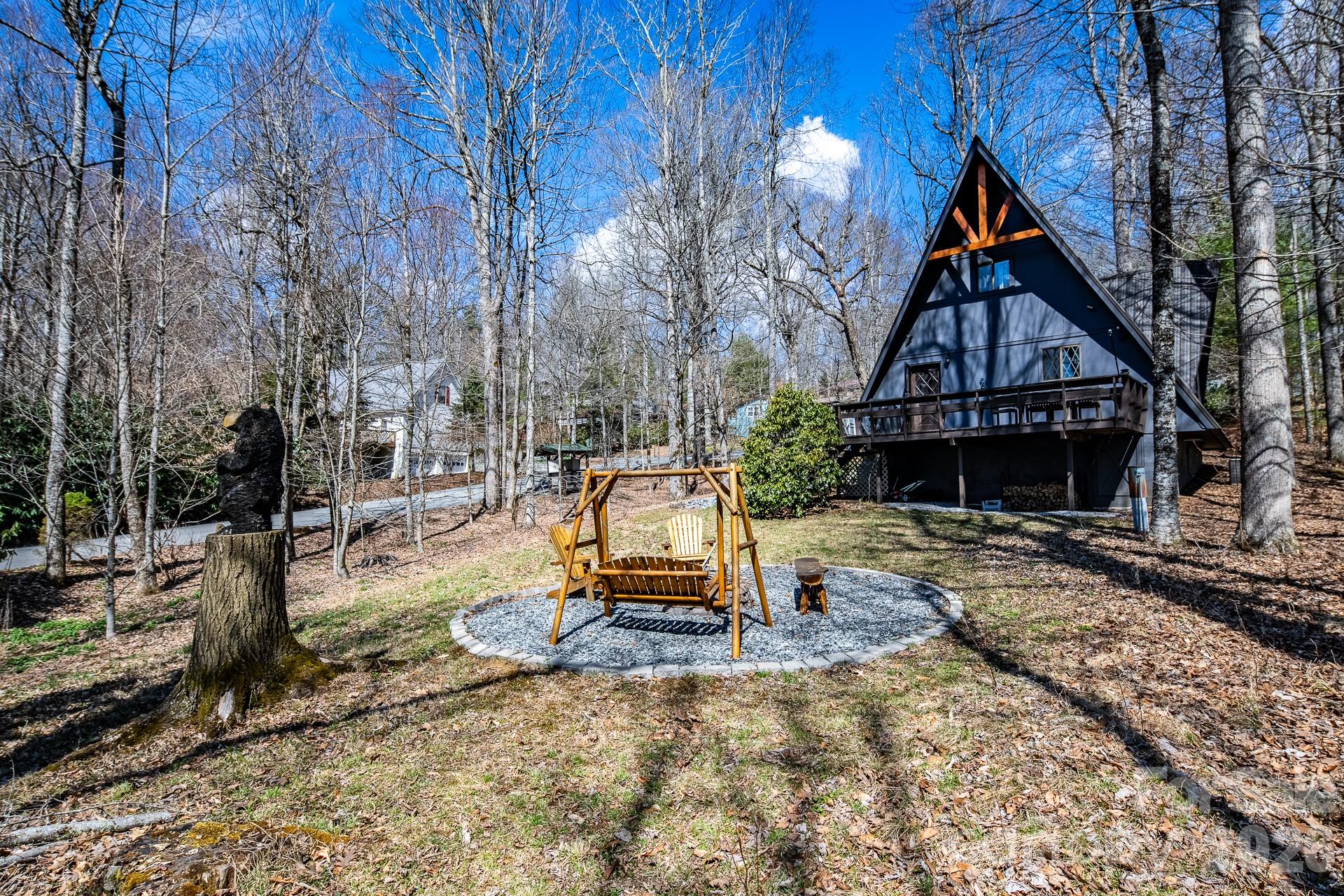 Discover the mountain gem you have been waiting for. Park the car and retire the keys because this prime location is just steps away from the 45 acre lake, heated pool, beach, game room and a variety of activities. This turnkey mountain retreat comes fully furnished featuring 3-bedrooms and 2 baths. The updated kitchen features stainless steel appliances and beautiful granite countertops, with a new gas range ready for the avid cook. Gather around the gas-log fireplace for a warm atmosphere while admiring the stunning murals. Step outside to a large deck for entertaining, overlooking an inviting fire pit area and nice yard for the dog and kids to play. This level spacious lot offers a variety of trees and plants, including rhododendrons, hemlock, and wildflowers. The home includes additional upgrades like a newer HVAC, metal roof, and driveway with convenient walk-in storage underneath the home. No updates or fixes required, just arrive and start living the mountain life. Linville Land Harbor is a sought-after community that includes water, cable, internet, 24/7 security, road maintenance, snow removal, weekly curbside trash removal, heated seasonal pool, nice sandy beach, stocked fishing waters, hiking, 18 hole golf course, clay like Har-Tru tennis courts, dedicated pickleball courts, covered shuffleboard courts, dog park, play ground holiday festivities, and seasonal concerts. Whether you choose to make this your full-time residence, a seasonal retreat, or keep it in the rental pool, all you need to bring is your suitcase to start enjoying mountain living at its finest! Must see to truly appreciate.
